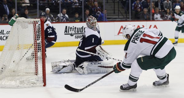 Minnesota Wild left wing Zach Parise, front, scores a goal past Colorado Avalanche goalie Semyon Varlamov, of Russia, in the second period of an NHL h