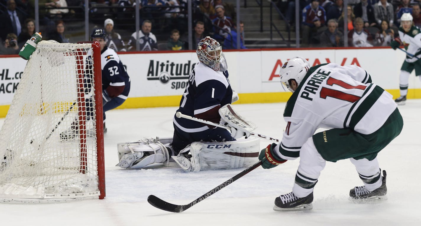 Minnesota Wild left wing Zach Parise, front, scores a goal past Colorado Avalanche goalie Semyon Varlamov, of Russia, in the second period of an NHL hockey game Saturday, March 26, 2016, in Denver. (AP Photo/David Zalubowski)