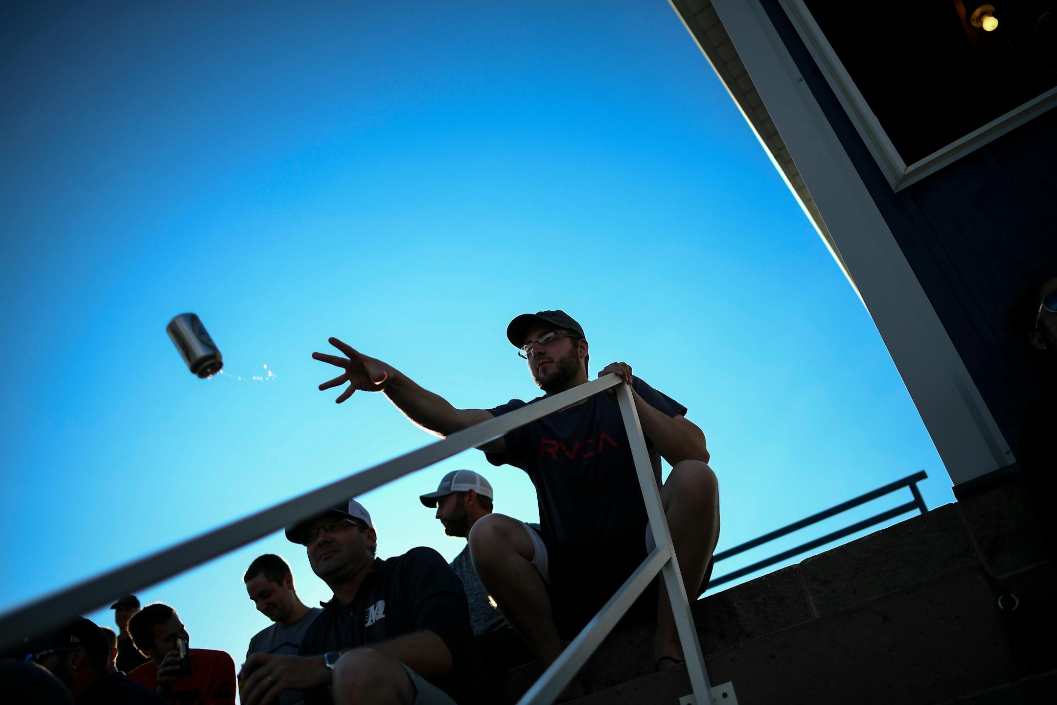 Darren Wander, of Elrosa, tossed a beer can onto the top of the dugout during the all-star game between the Stearns County League and the County Line League on Friday, June 30, 2017 in Elrosa, Minn. Beer-drinking fans have made a game out of tossing their beers onto the dugout, with contestants trying to toss their beer as close to the edge of the dugout as possible, with many going over near the field of play.