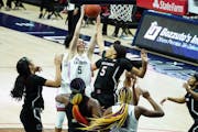 Connecticut guard Paige Bueckers (5) grabs a rebound against South Carolina forward Victaria Saxton (5) in the second half of an NCAA college basketba