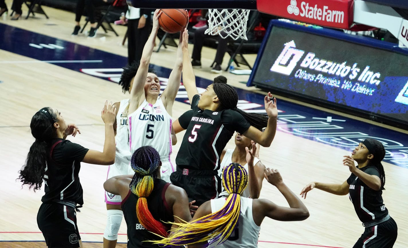 Connecticut guard Paige Bueckers (5) grabs a rebound against South Carolina forward Victaria Saxton (5) in the second half of an NCAA college basketball game in Storrs, Conn., Monday, Feb. 8, 2021. (David Butler/Pool Photo via AP)