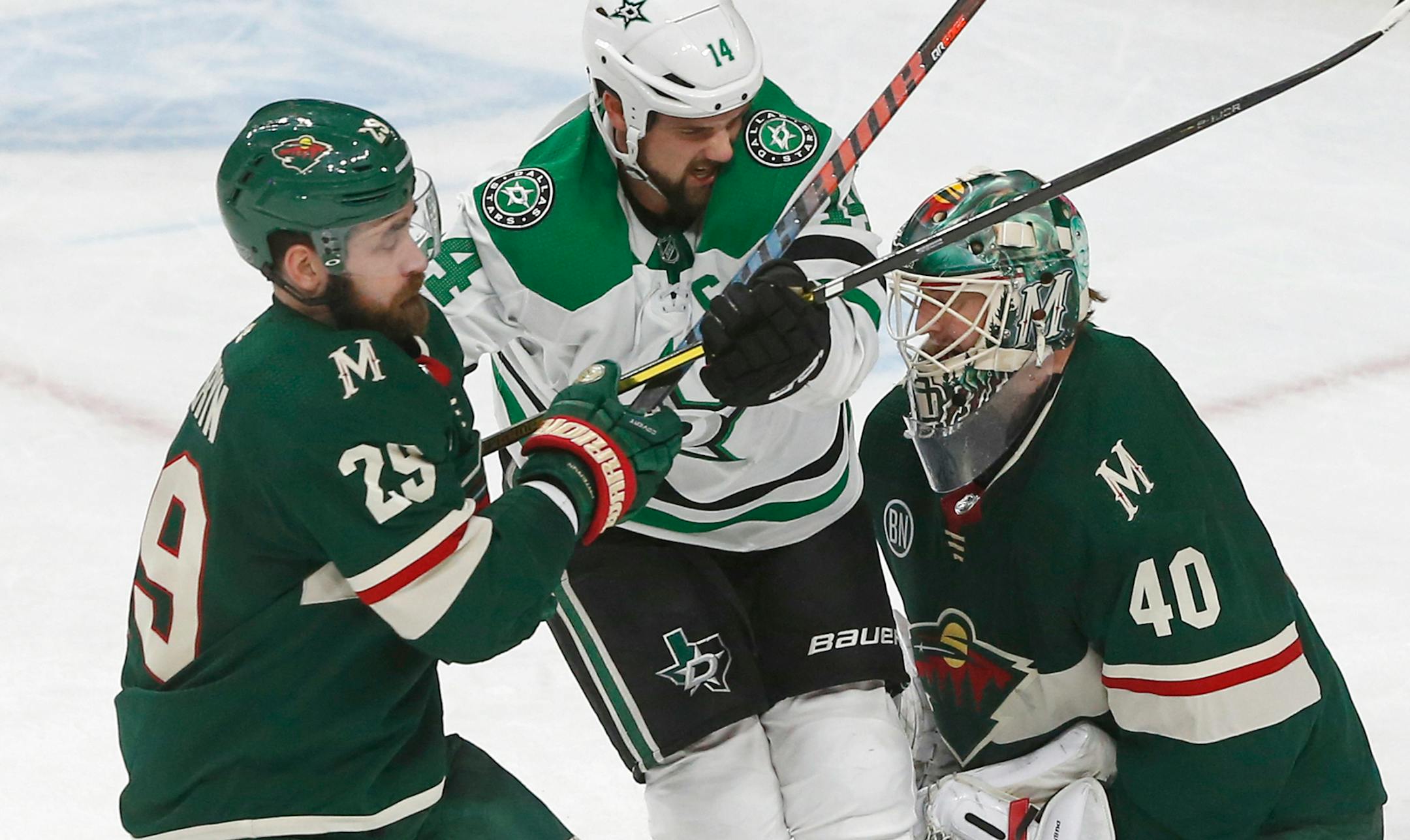 Dallas Stars' Jamie Benn, center, gets squeezed between Minnesota Wild's Greg Pateryn, left, and goalie Devan Dubnyk in the first period of an NHL hockey game Saturday, Dec. 22, 2018, in St. Paul, Minn. (AP Photo/Jim Mone)