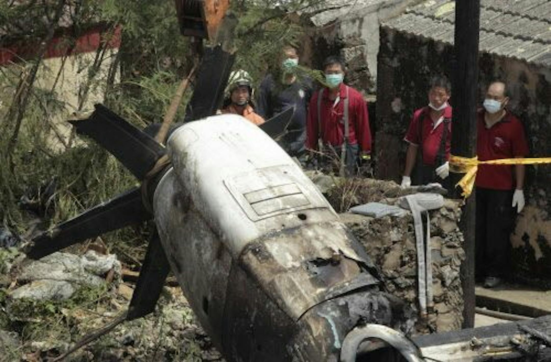 Emergency workers watch an engine lifted from the TransAsia Airways Flight GE222 crash site on the outlying Taiwan island of Penghu, Friday, July 25, 2014.