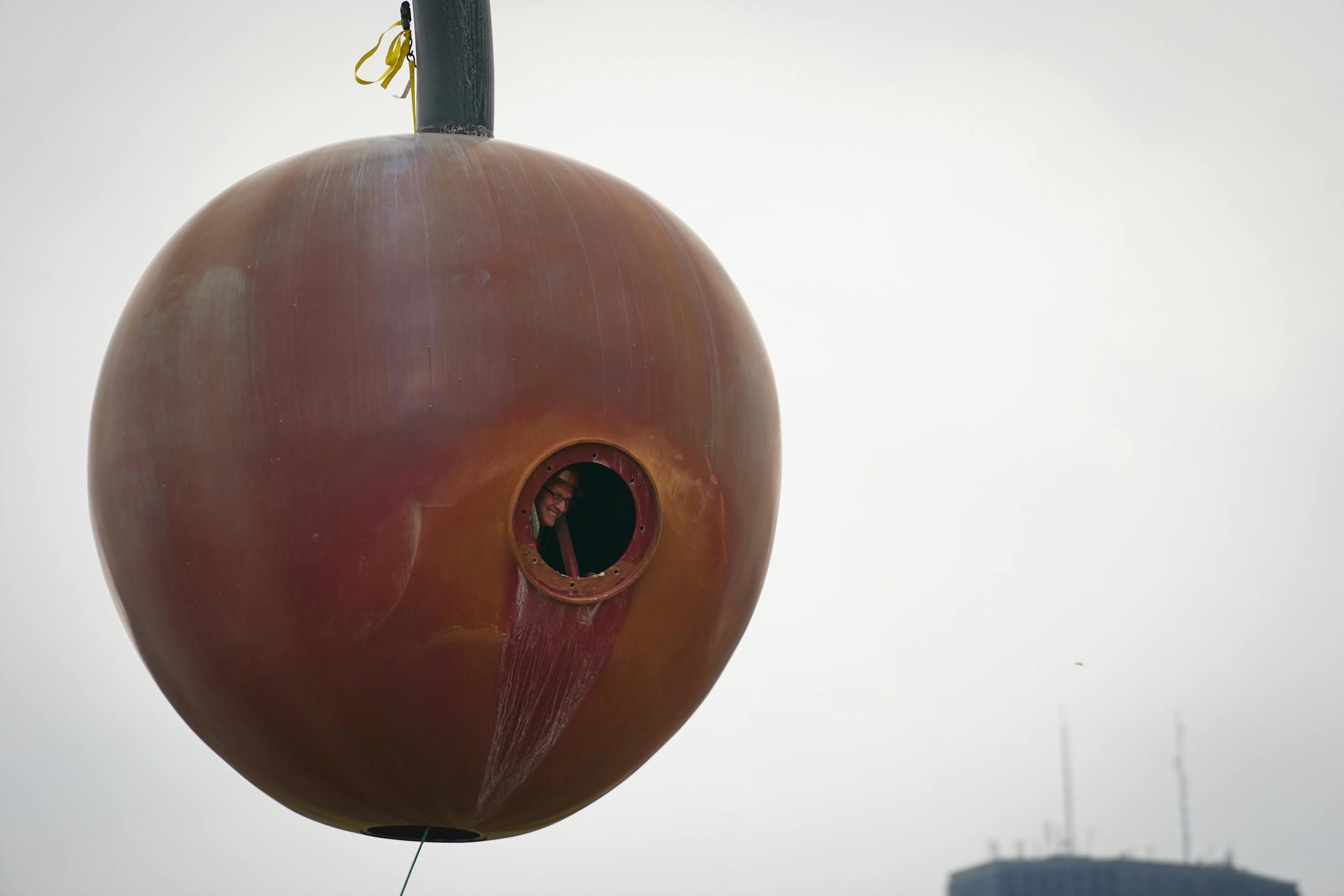 The 17500 pound aluminum cherry ball is unbolted, lifted, and separated from the Spoonbridge base it sits atop at the Sculpture Garden in Minneapolis, Minn., on Tuesday, Nov. 16, 2021. Due to the typically harsh conditions of Minnesota winters, this iconic Minneapolis fruit requires a fresh coat of paint about every ten years to keep the cherry's red crisp and glossy. Leon Budke, an employee with Rocket Crane Services, rides inside the cherry as it's moved from the spoon on to the ground. This wasn't Budke's first ride in the cherry; he's taken the ride previously and joked he may come out of retirement the next time the cherry is moved. ] SHARI L. GROSS • shari.gross@startribune.com