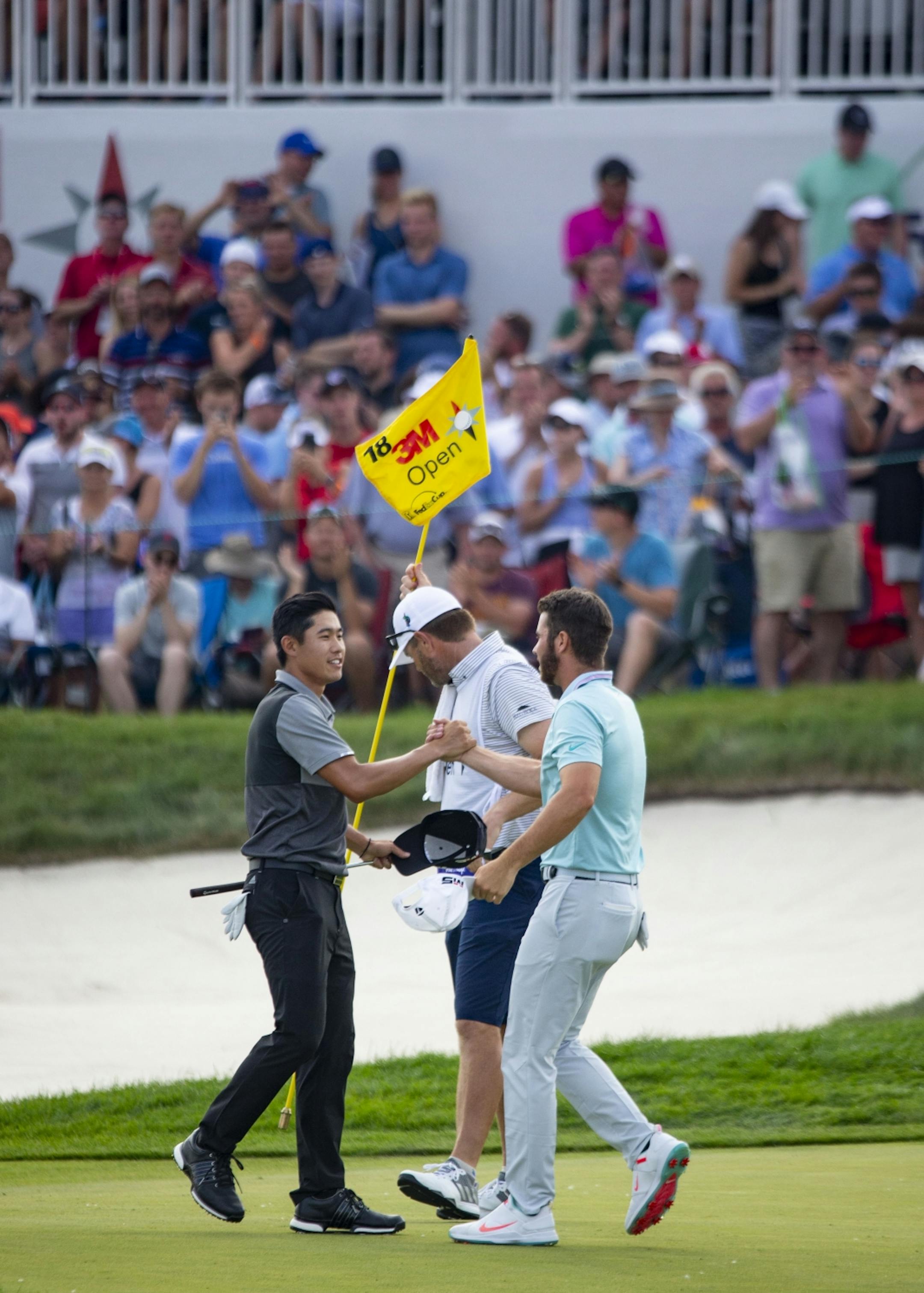 Matthew Wolff and Collin Morikawa shake hands after finishing the 18th hole.