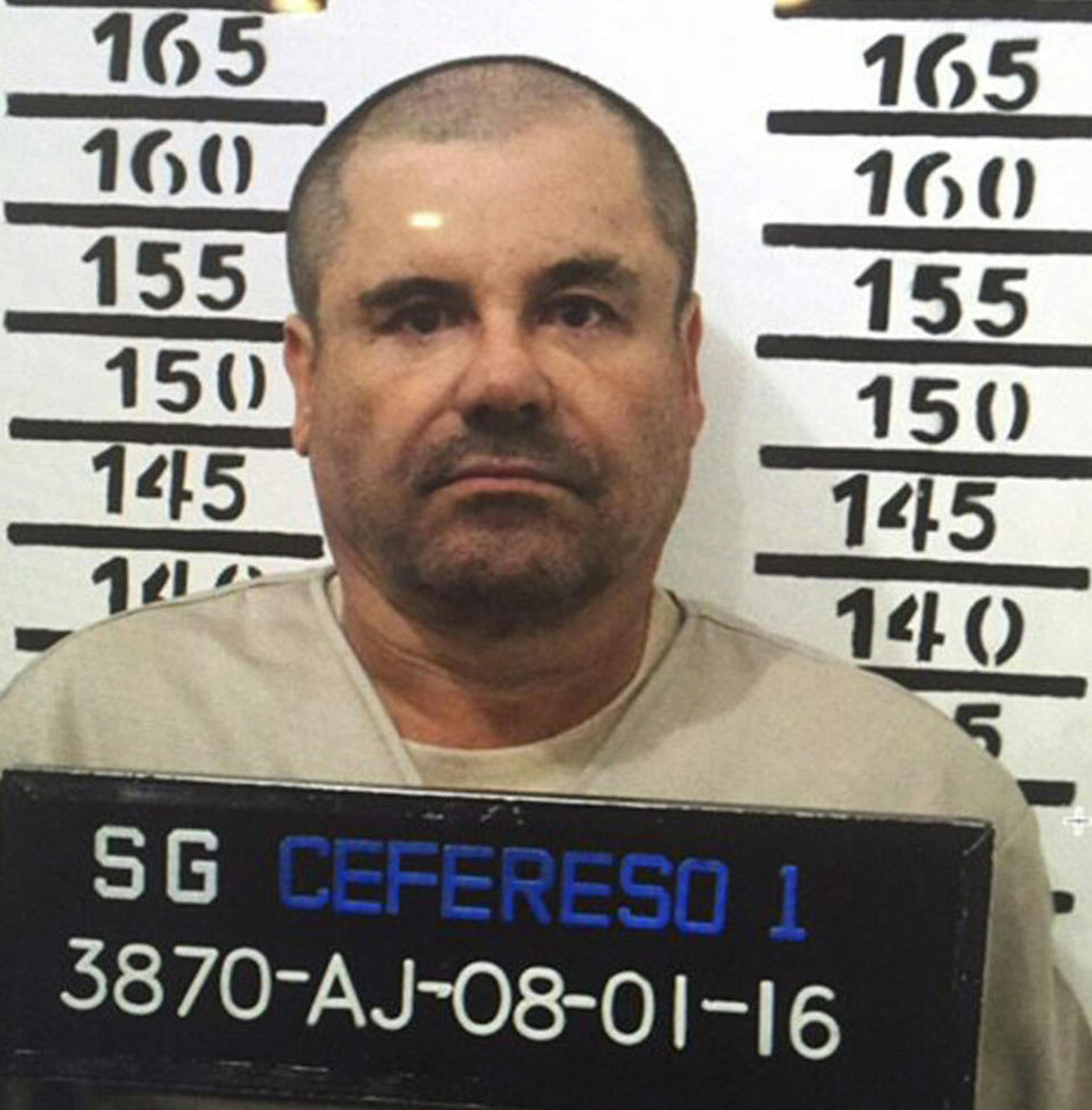 In this Jan. 8, 2016 image released by Mexico's federal government, Mexico's most wanted drug lord, Joaquin "El Chapo" Guzman, stands for his prison mug shot, with the inmate number 3870 at the Altiplano maximum security federal prison in Almoloya, Mexico. Mexico has begun the process of extraditing Guzman to the United States, where he faces drug-trafficking charges, but that could take "a year or longer" because of legal challenges, said the head of Mexico's extradition office, Manuel Merino.