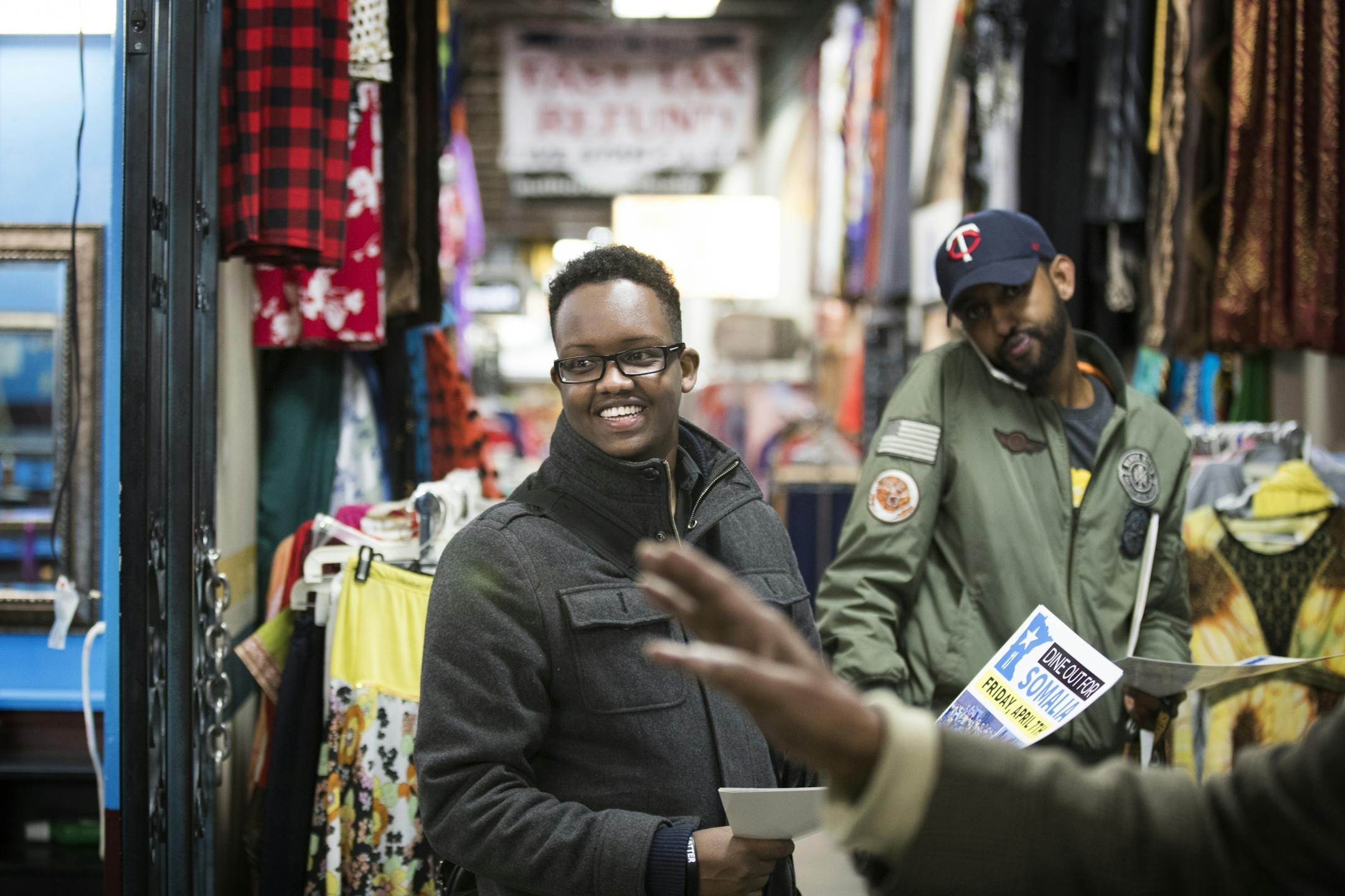 Khalid Mohamed, left, talks to Guled Hassan, right, and others about supporting Dine Out for Somalia while at Village Market.