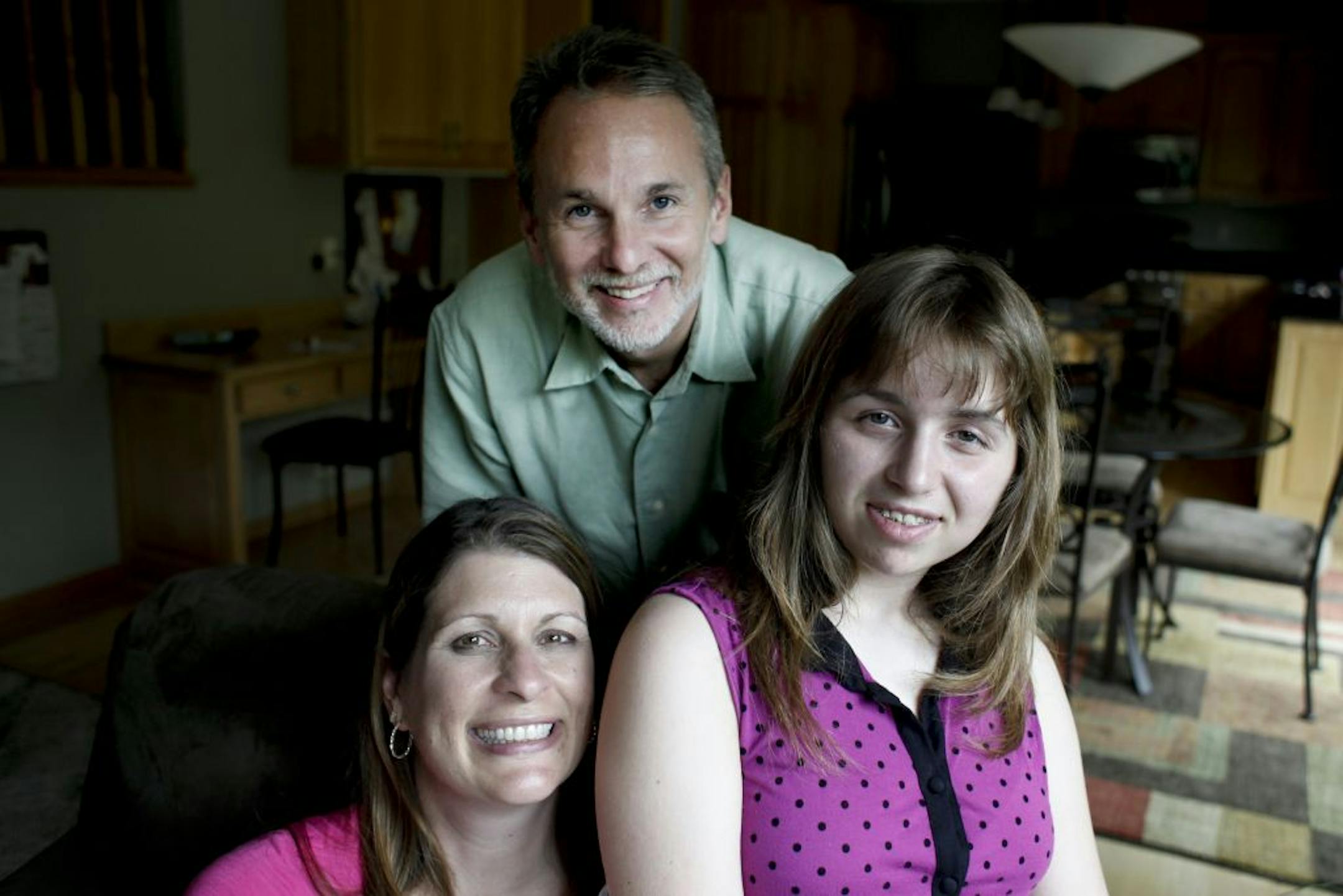 Lisa, Paul and Hannah Meunier, 13, huddle close together in their house in Ham Lake, Minn. on Thursday, July 19, 2012. To honor of his daughter Paul Meunier, the former mayor of Ham Lake, is going to live in his tiny (14-foot) fishing boat for three days and nights in August to raise awareness and money for research to combat epilepsy.
