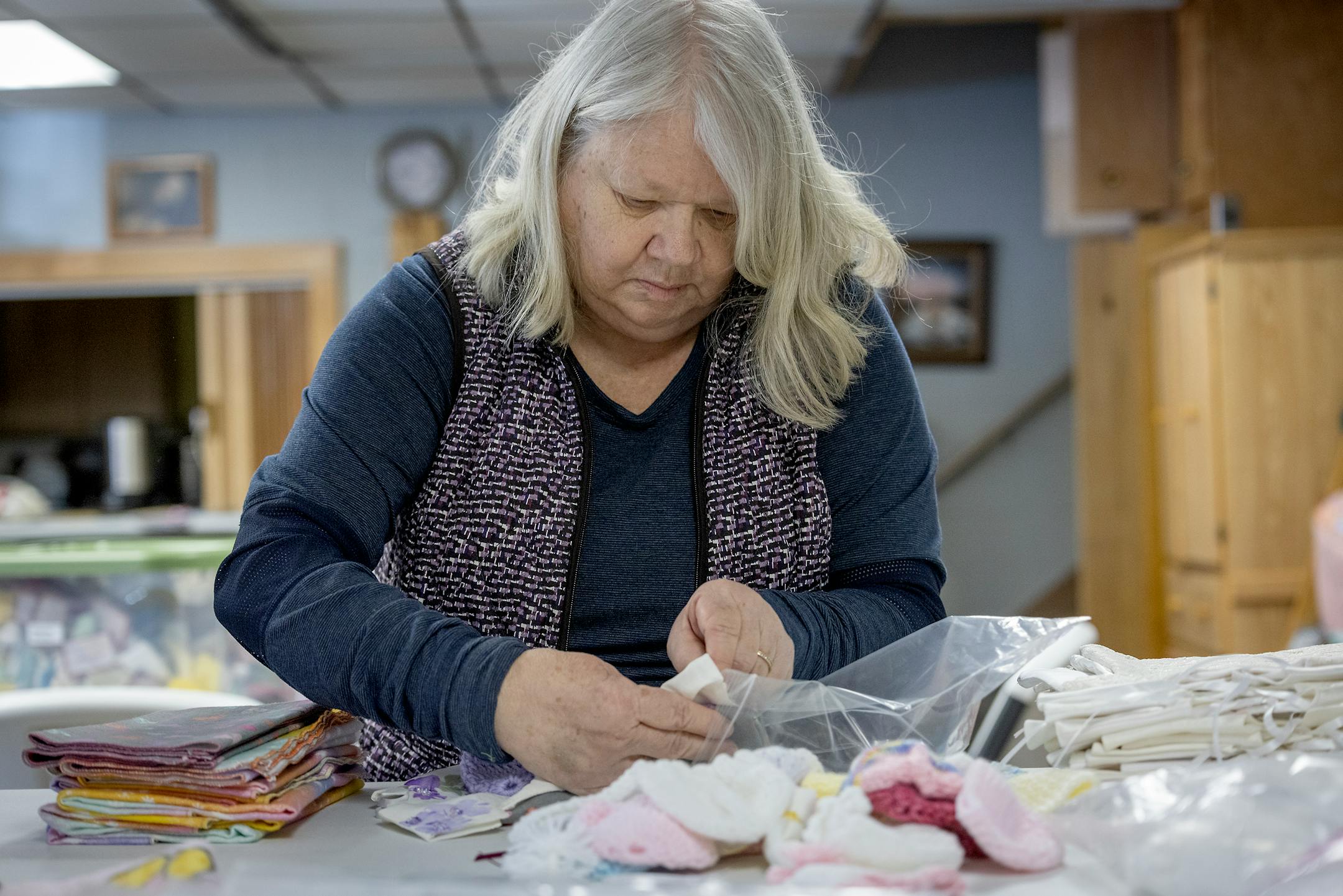 Barb Rose packages "Angel Dresses" for delivery in the All Saints Lutheran Church basement in  Darwin, Minn.