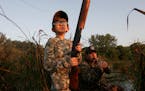 Grace Rodemann, 11, of Carver eyed a Canada goose winging over Carver Marsh on her first-ever waterfowl hunt. Calling the goose was her mentor, John W