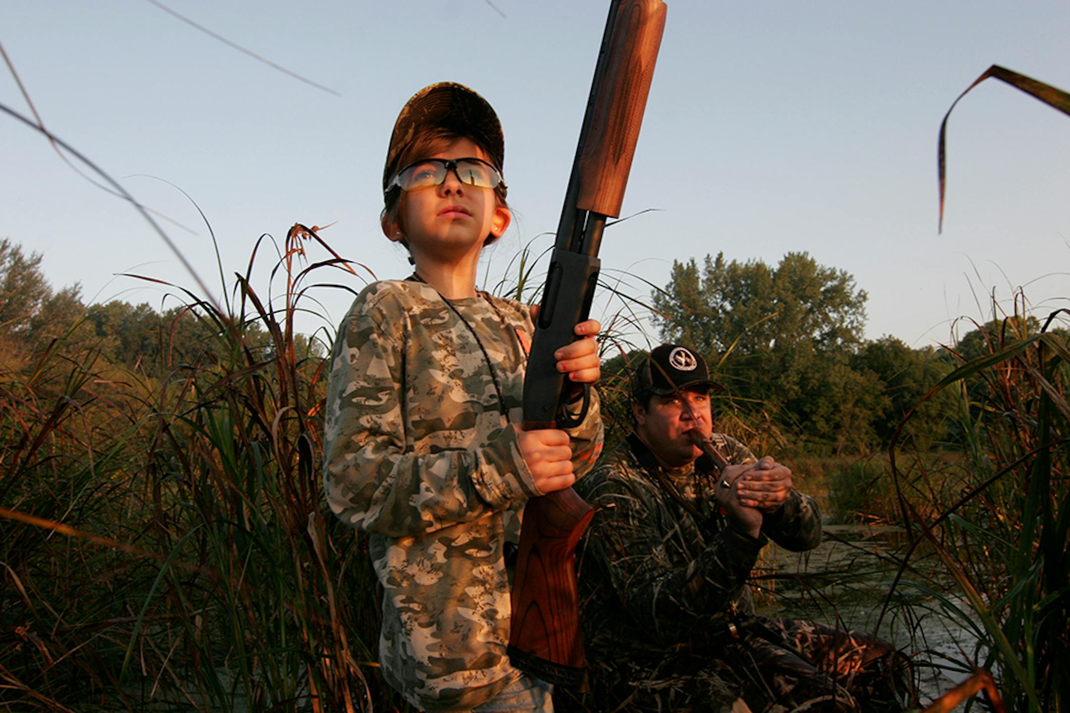 Grace Rodemann, 11, of Carver eyed a Canada goose winging over Carver Marsh on her first-ever waterfowl hunt. Calling the goose was her mentor, John Wartman, 47, of Waconia.