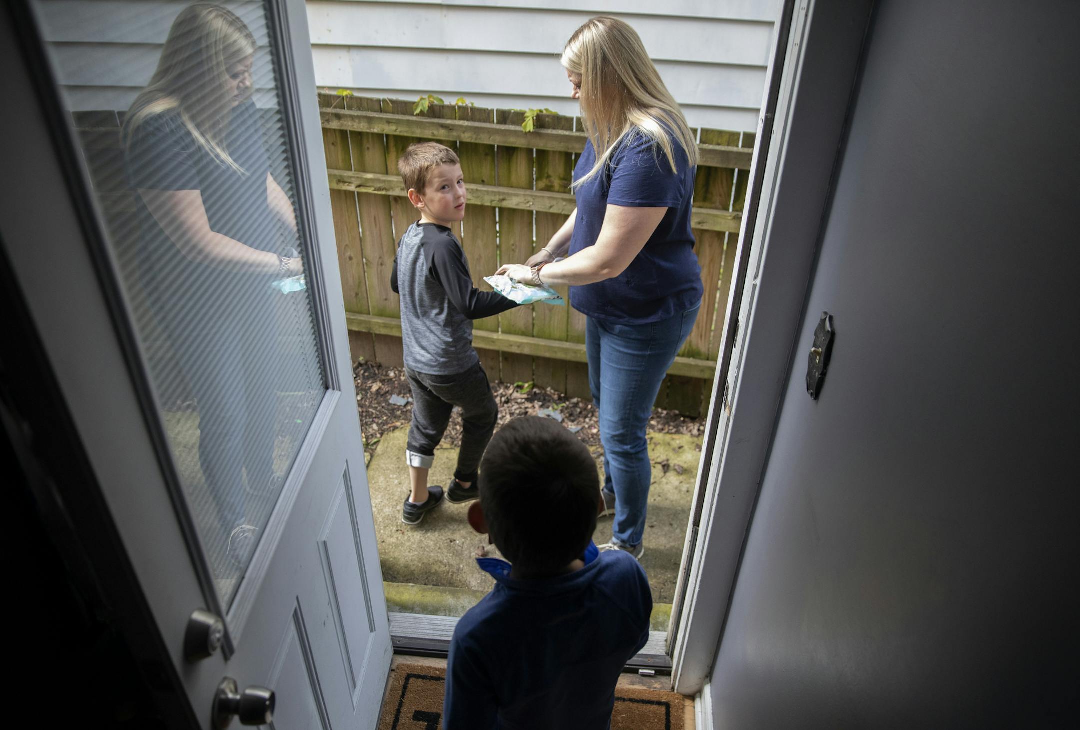 Kira Meinzer with her twin 5-year-old boys Caden, front, and Reillen Mihelbergel outside their home, May 29, 2019, in Evanston. Meinzer implemented a program to let employees of PowerReviews work with a local sleep consultant to help new parents with children having sleep issues. (Erin Hooley/Chicago Tribune/TNS) ORG XMIT: 1326810