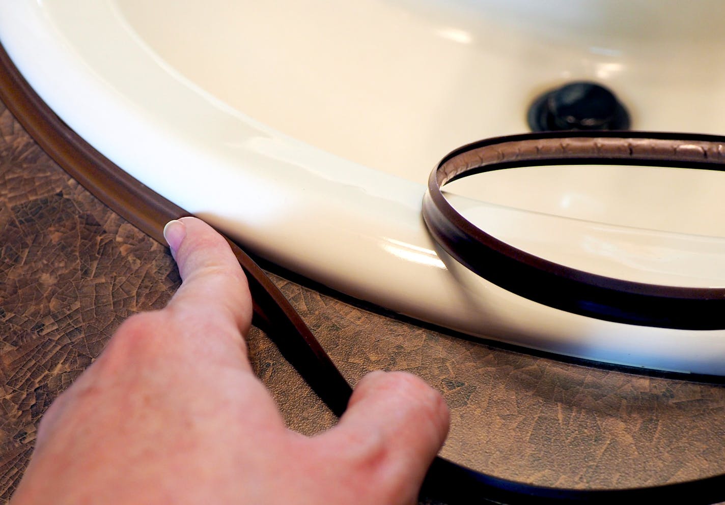 Minnesota-made InstaTrim is shown being applied around a sink.