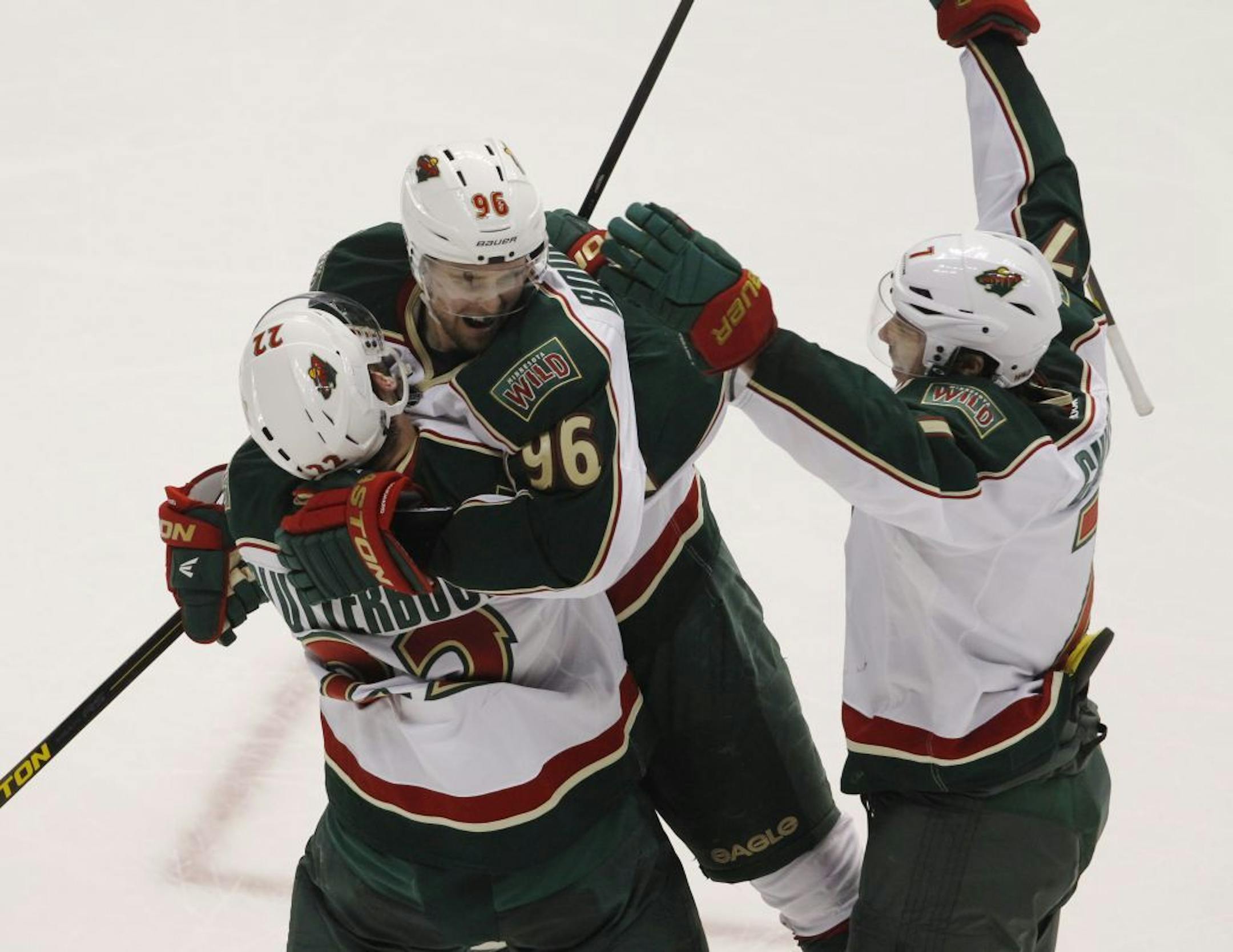 Minnesota Wild left wing Pierre-Marc Bouchard, center, celebrates after his open-net goal with right wing Cal Clutterbuck, left, and center Matt Cullen late in the third period of the Wild's 3-1 victory over the Colorado Avlanche in an NHL hockey game in Denver on Saturday, April 27, 2013. With the win, the Wild earned the eighth seed in the NHL Western Conference playoffs.