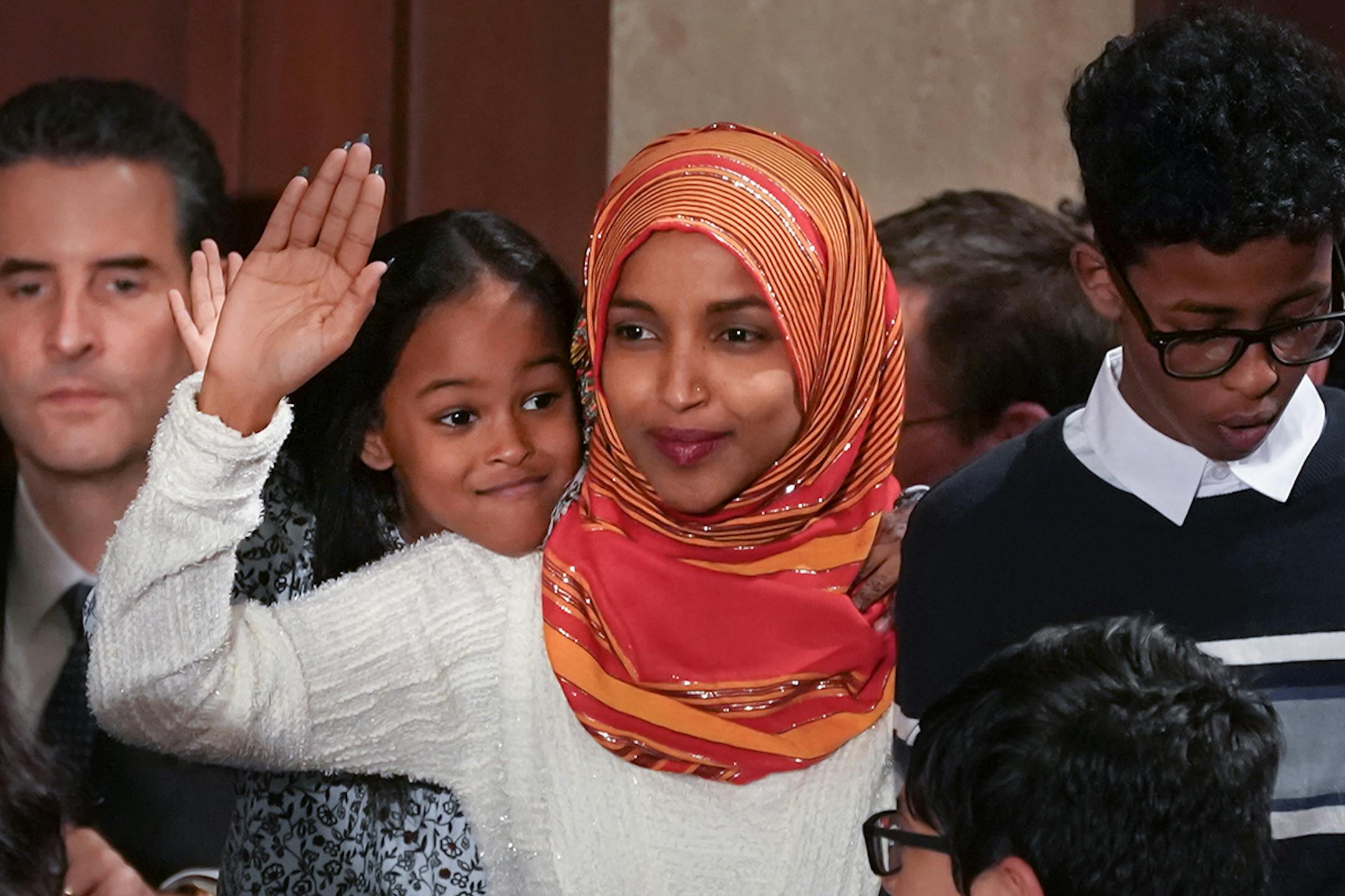 Rep. Ilhan Omar, D-Minn, was one of five new Representatives sworn in on the United States House floor, Thursday, Jan. 3, 2019, in Washington. Omar's daughter, Ilwad, peaks over her shoulder.