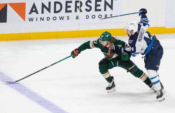 Kirill Kaprizov was hassled by Jets defenseman Josh Morrissey (44) in overtime Tuesday. Morrissey was penalized, and the Wild scored on a power play t