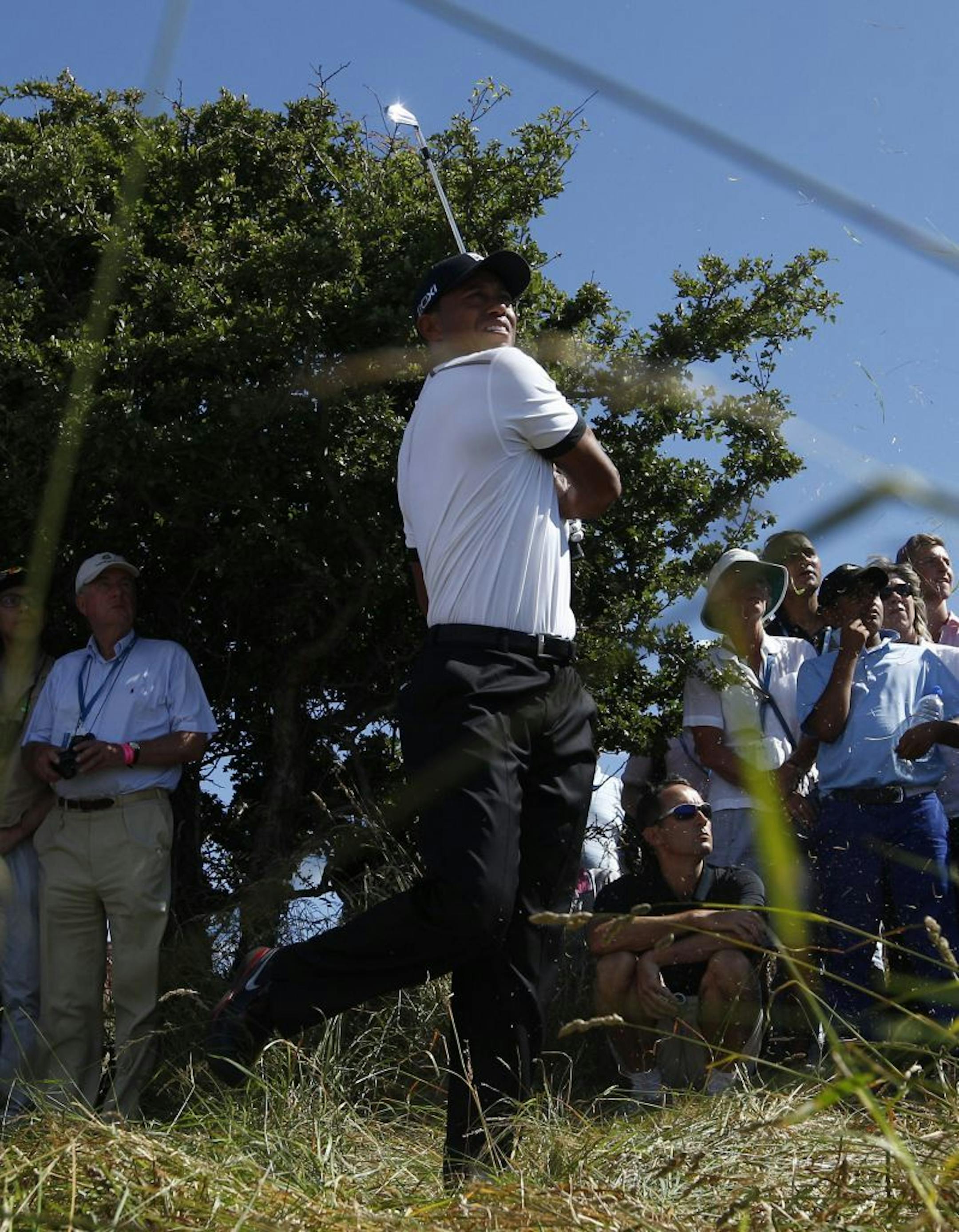 Tiger Woods of the United States plays out of the rough on the first fairway during the first round of the British Open Golf Championship at Muirfield, Scotland, Thursday July 18, 2013.