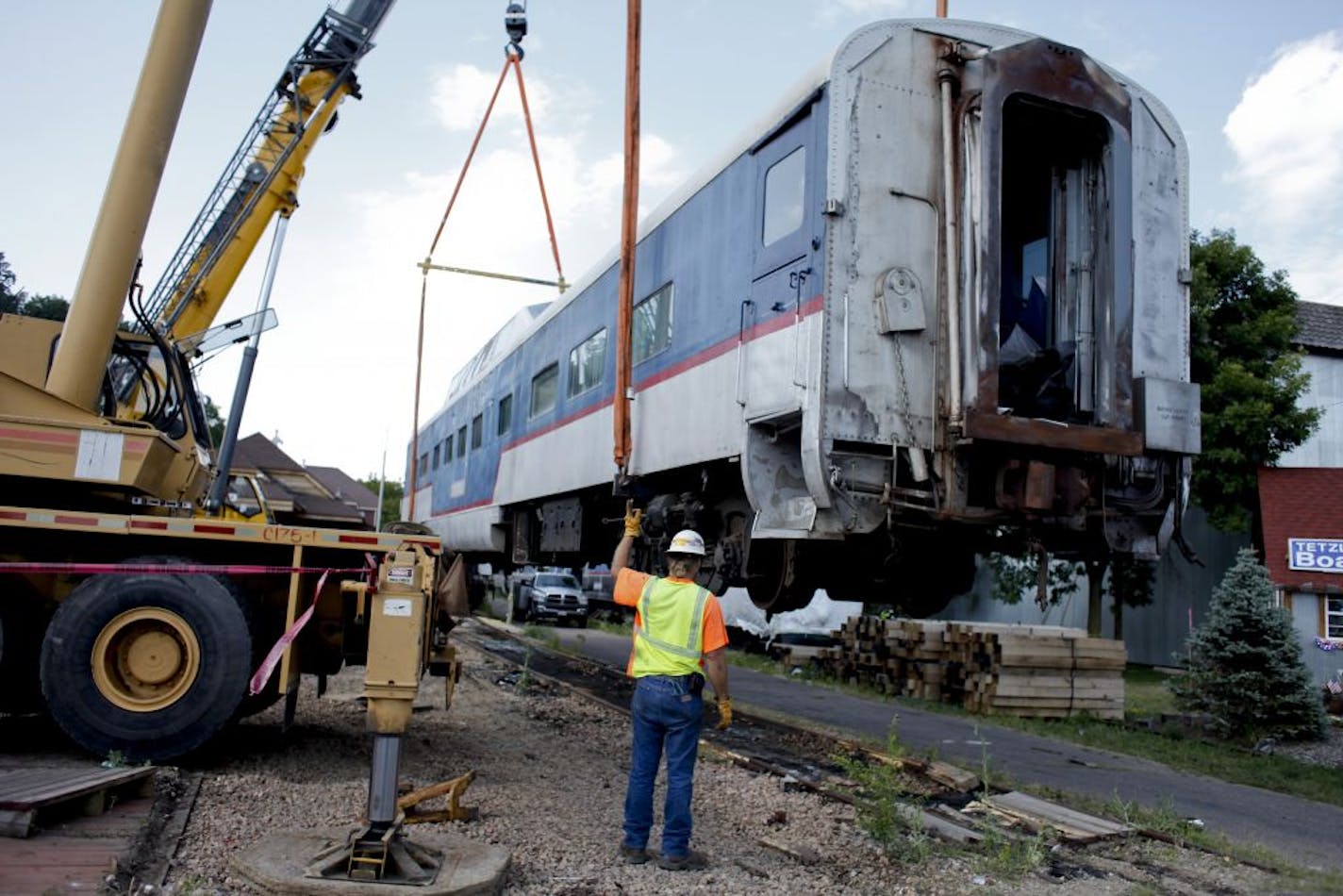 Troy Komulainen directed a crane as it lifted a train car from the Minnesota Zephyr onto a flatbed trailer. Each car weighs about 160,000 pounds.