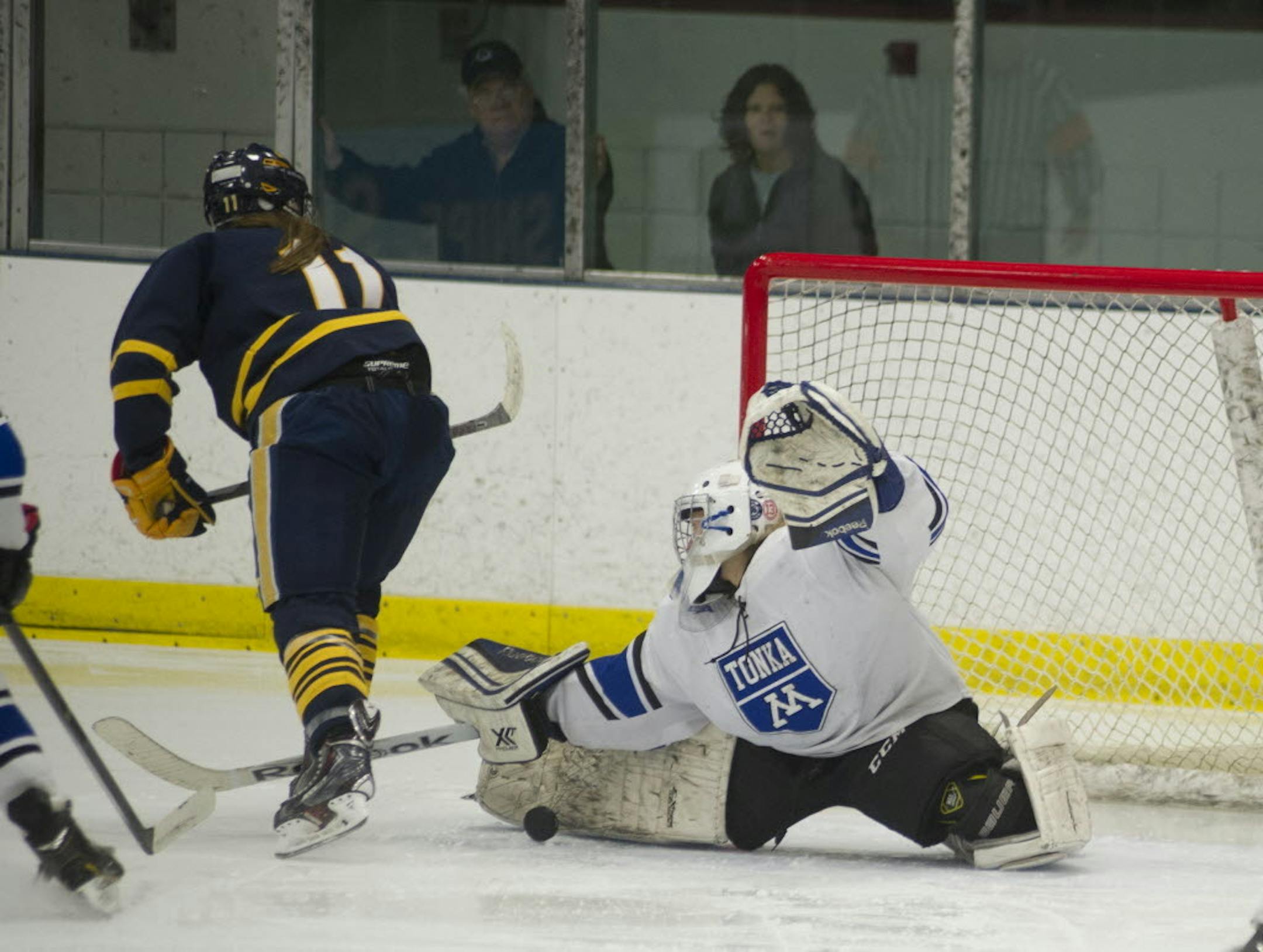 Minnetonka goalie Taty Delaittre makes a save on a shot from Wayzata's Izzy Shannon during the third period of Friday night's game at the Parade Ice Gardens in Minneapolis.