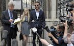 The parents of sick baby Charlie Gard, Connie Yates and Chris Gard, right, stand together as a statement is read by a family friend to the media, outs