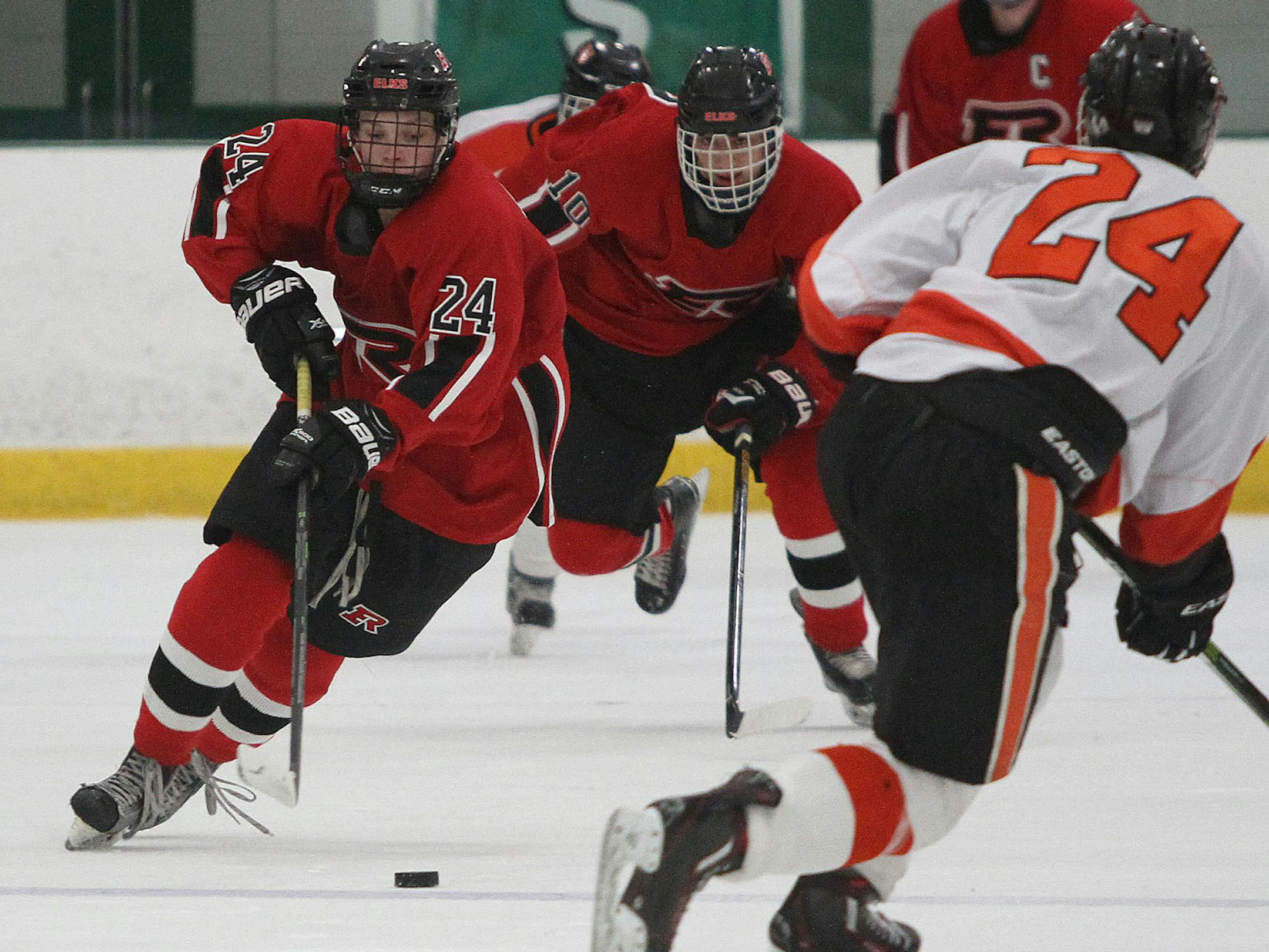 Nate Horn of Elk River carried the puck up ice against Grand Rapids, teammate Kyle Bouten (#10) trailed. Dec. 17 game at Braemar Arena in the Edina Classic Tournament. Horn, a senior forward and the Elks' leading scorer this season, scored the Elks' first goal in a 3-1 victory.