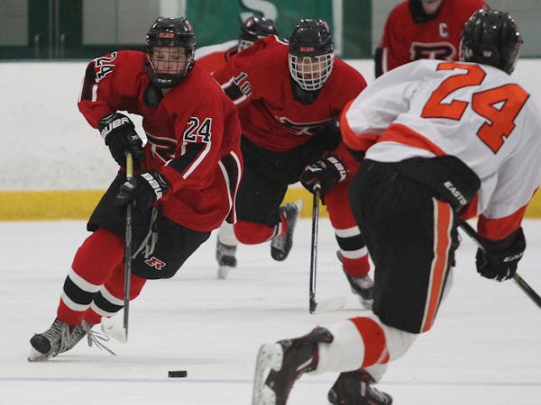 Nate Horn of Elk River carried the puck up ice against Grand Rapids, teammate Kyle Bouten (#10) trailed. Dec. 17 game at Braemar Arena in the Edina Cl