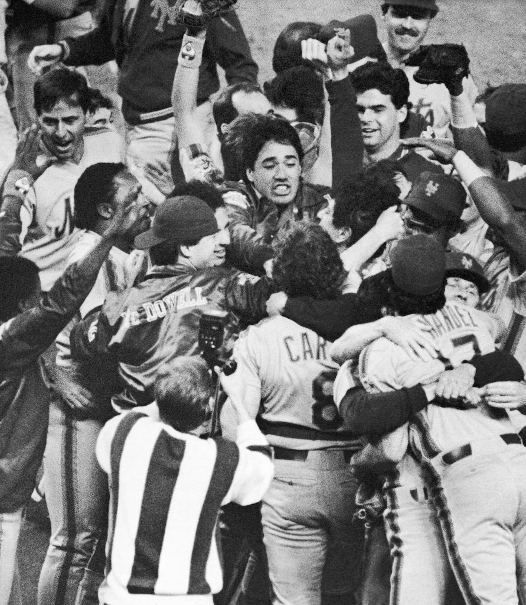 The New York Mets crowd around pitcher Jesse Orosco after the Mets won the National League pennant over the Houston Astros in Houston on Wednesday, Oct. 16, 1986.