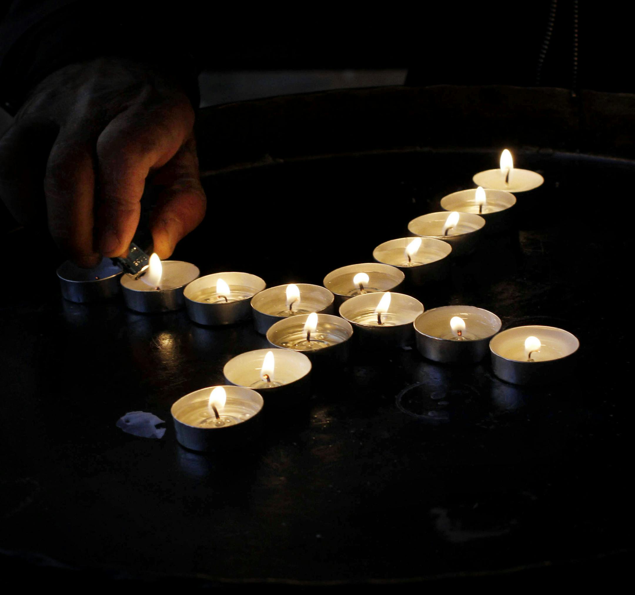 A Christian man lights candles in the Church of the Nativity, ahead of Christmas in the West Bank city of Bethlehem, Monday, Dec. 23, 2013. Christians around the world will celebrate Christmas this week. (AP Photo/Nasser Shiyoukhi)