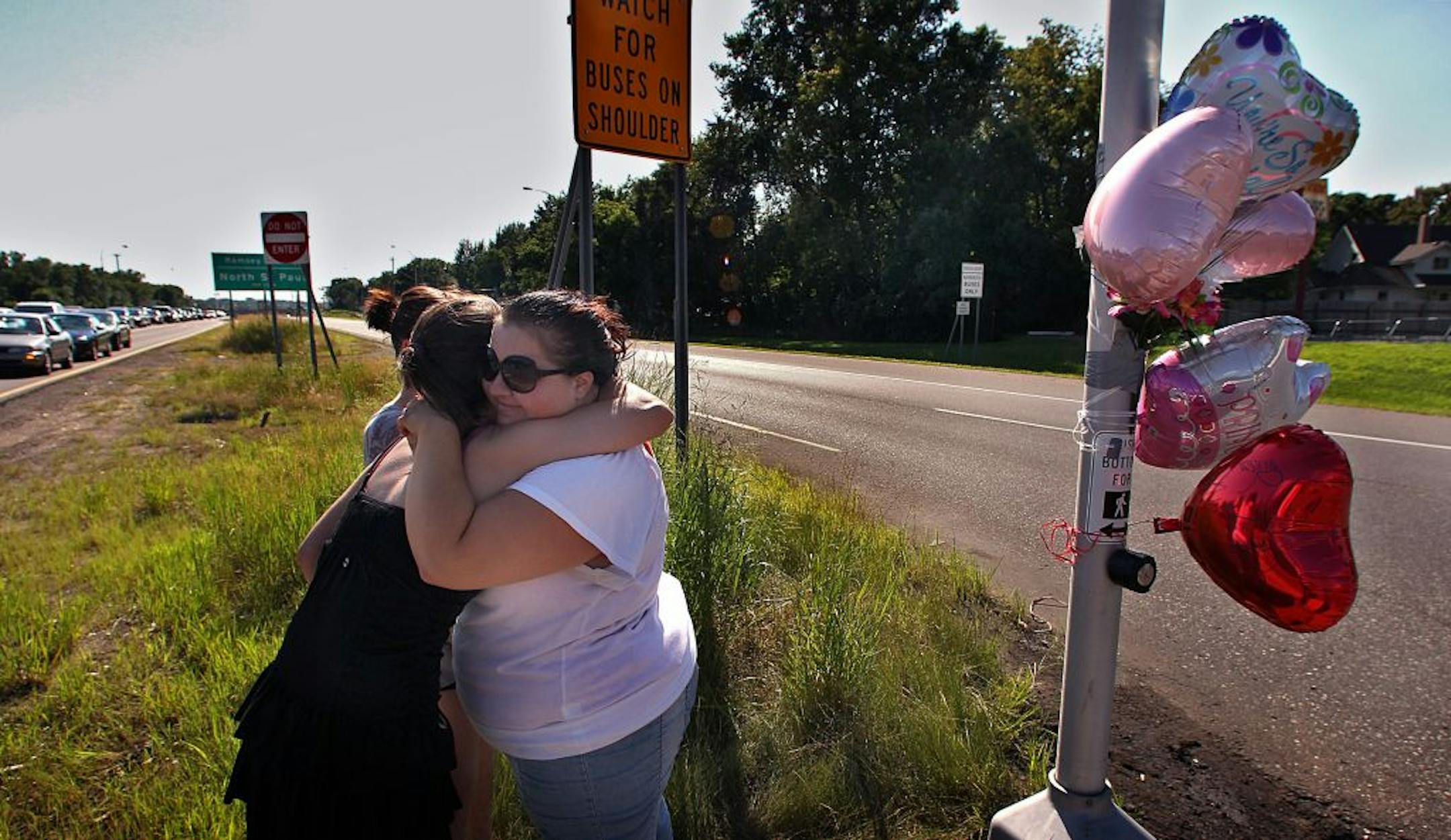 Vehicles travel at a very high rate of speed as they travel along Hwy. 36 (road left to right), where it intersects Hwy. 120, Century Ave. in North St. Paul. The intersection was the scene Thursday night, where a woman pushing her son in a stroller was hit and killed as she crossed Hwy. 36. Friday afternoon, friends of 23-year-old Alicia Galdick who was killed at the intersection gathered to add to a makeshift memorial. Jennifer Niedermayer, 23, Oakdale (facing camera) embraced Sarah Emerson, 22