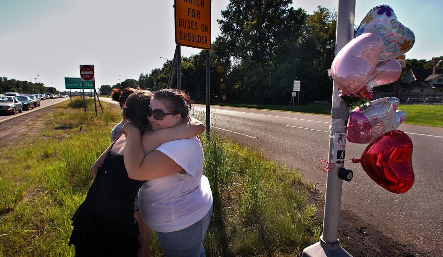 Vehicles travel at a very high rate of speed as they travel along Hwy. 36 (road left to right), where it intersects Hwy. 120, Century Ave. in North St. Paul. The intersection was the scene Thursday night, where a woman pushing her son in a stroller was hit and killed as she crossed Hwy. 36. Friday afternoon, friends of 23-year-old Alicia Galdick who was killed at the intersection gathered to add to a makeshift memorial. Jennifer Niedermayer, 23, Oakdale (facing camera) embraced Sarah Emerson, 22