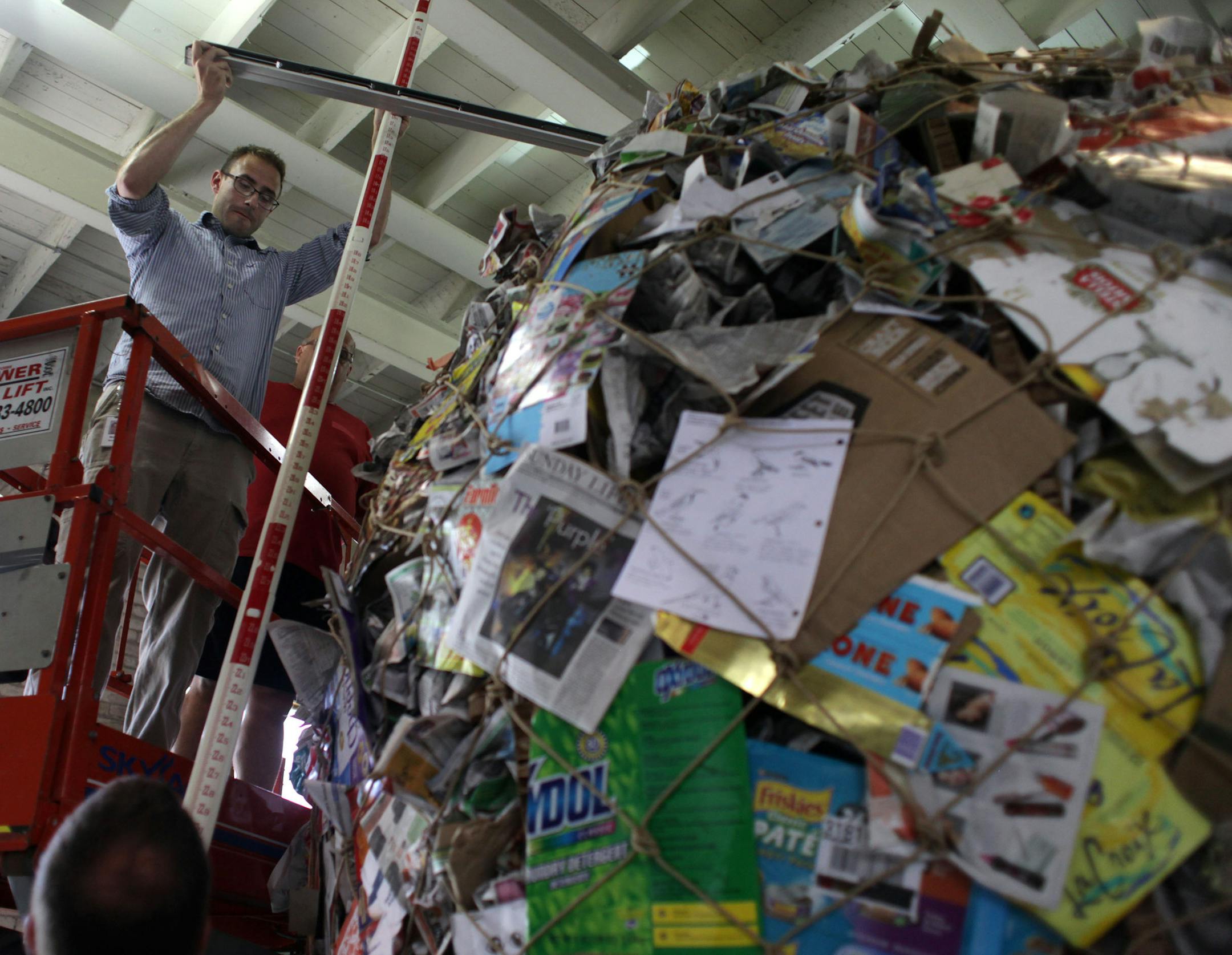 Nate Straka measures the height of a giant paper ball created by the Minnesota Pollution Control Agency on Wednesday afternoon at the State Fair.] The Minnesota Pollution Control Agency created what they hope to be the world's largest ball of paper, weighing 426 pounds, with an average circumference of 32.22 feet. On Wednesday afternoon, a surveyor from Three Rivers Park district took the official measurements. The ball will be on display in the Eco Experience Building at the State Fair. MONICA
