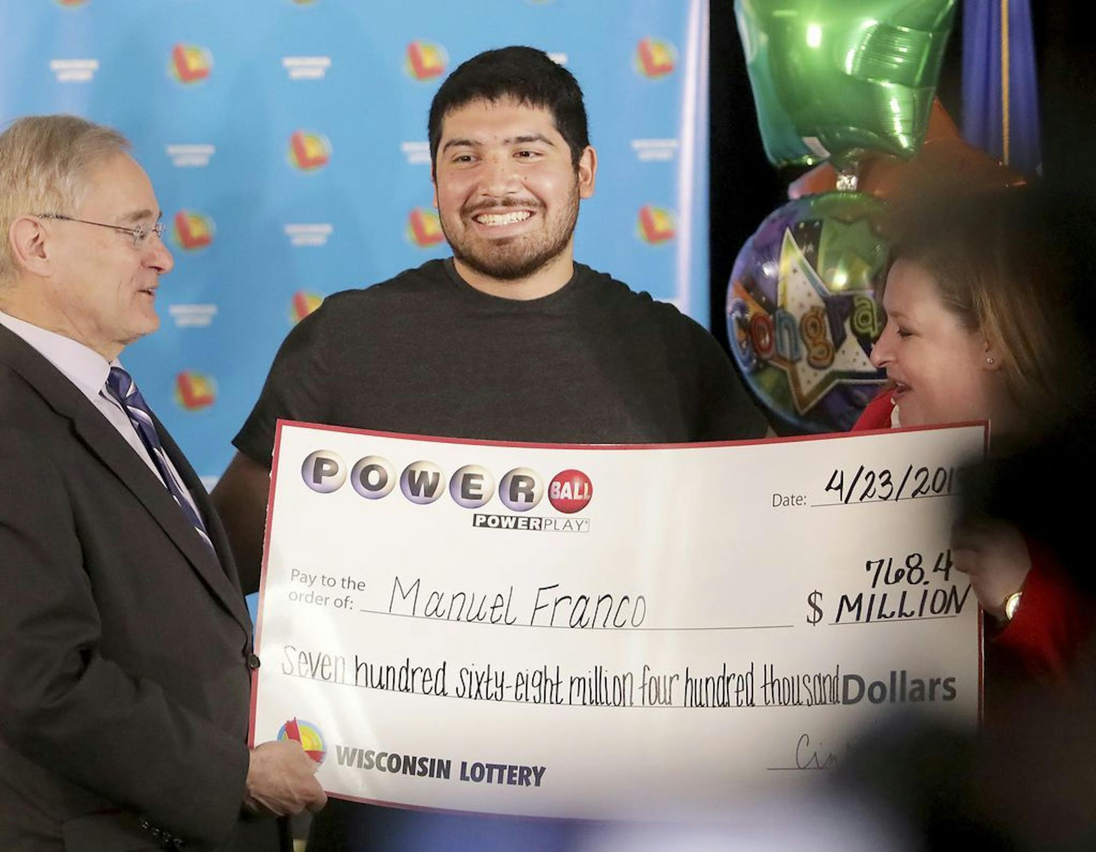Manuel Franco of West Allis, Wis., winner of second-highest Powerball lottery in history, attends a news conference at the Wisconsin Department of Revenue in Madison, Wis., on Tuesday, April 23, 2019. At right is Peter Barca, state secretary of revenue, and at right is Cindy Polzin, state lottery director. Franco claimed the cash option payout of the prize, totaling approximately $477 million before taxes. The overall jackpot of the prize, drawn March 22, was $768,400.