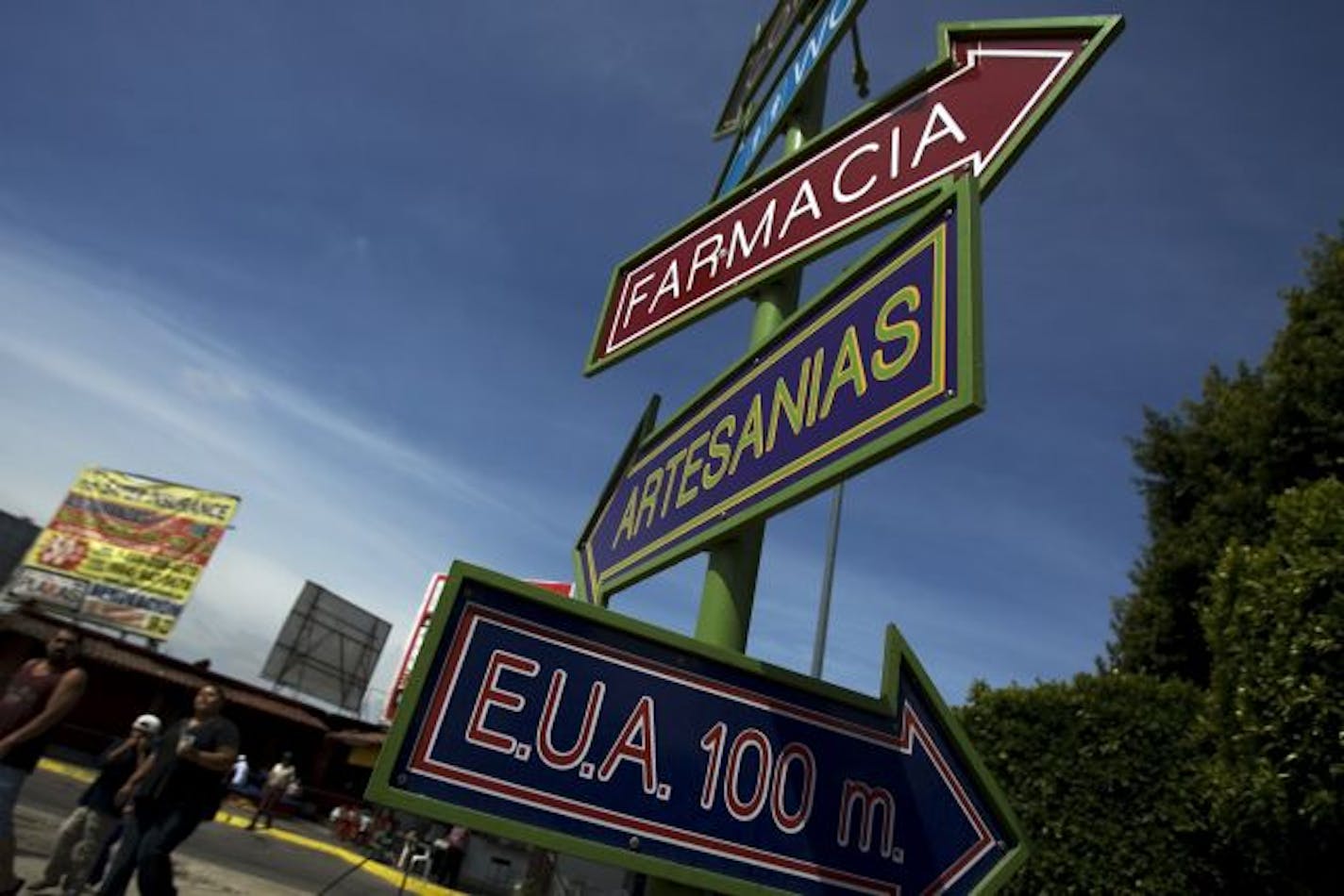 Signs, reading in Spanish "Drugstore, handicrafts and U.S. 100 meters," are seen at the international border crossing between San Ysidro, CA, and Tijuana, in Mexico.