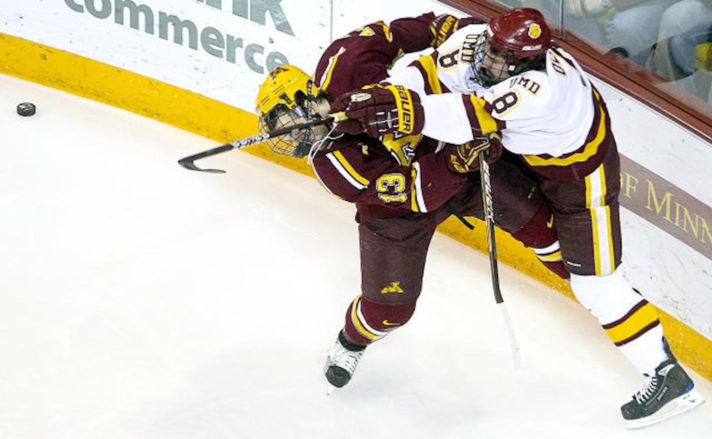 Minnesota Duluth's Drew Olson (8) checks Minnesota's Nico Sacchetti (13) during an NCAA college hockey game on Friday, Feb. 4, 201, in Duluth, Minn.