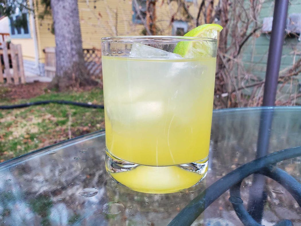 Cocktail made with Earl Giles orange-lime elixir and rum, with a Minnesota Ice cylinder