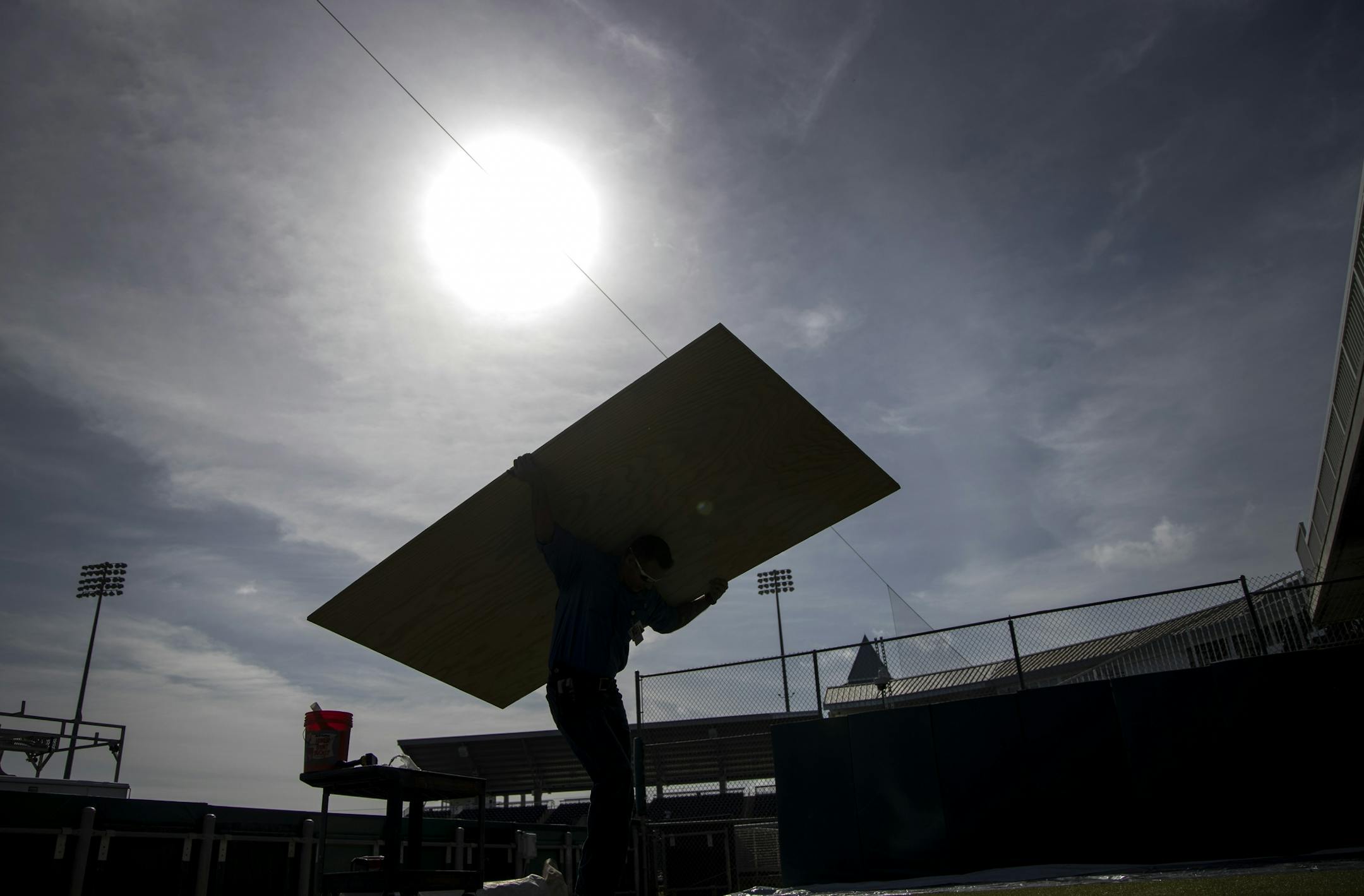 Willis Brown carried a board to be padded for use on the outfield fence of Hammond Stadium.