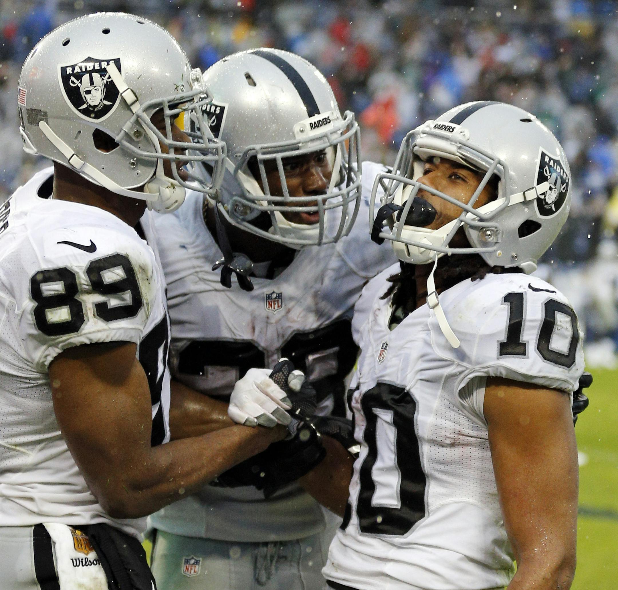Oakland Raiders wide receiver Seth Roberts (10) celebrates with Amari Cooper (89) and Latavius Murray, center, after Roberts caught a 12-yard touchdown pass in the fourth quarter to give the Raiders a 24-21 win over the Tennessee Titans in an NFL football game Sunday, Nov. 29, 2015, in Nashville, Tenn.(AP Photo/Weston Kenney)