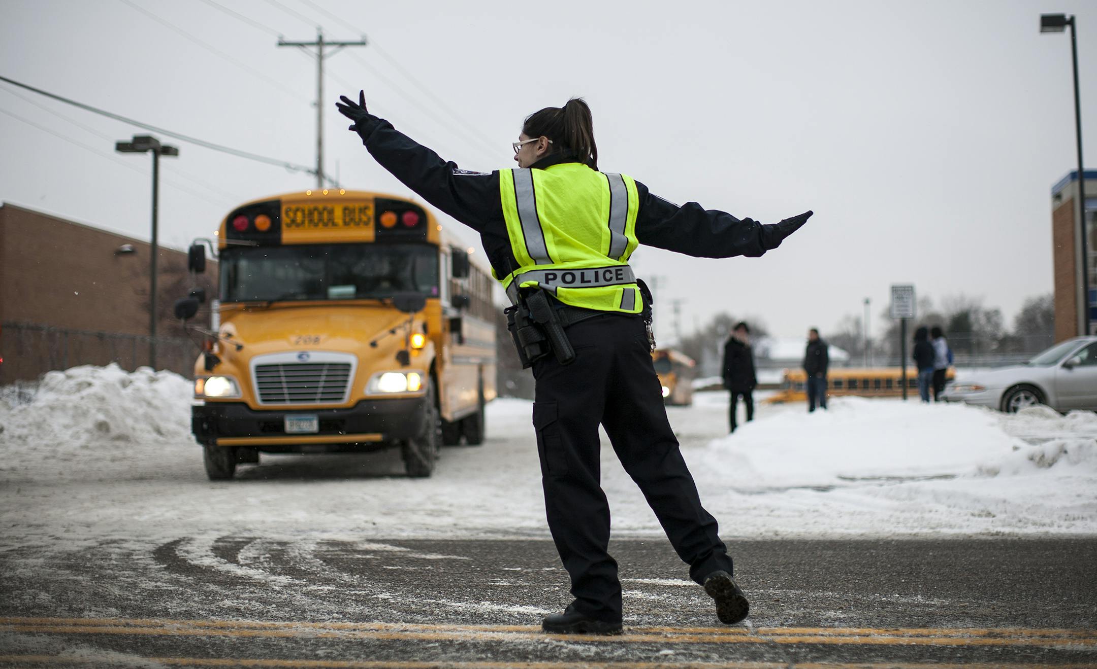 Police officer Jackie Duchschere directs traffic after school for Valley View Elementary School and Columbia Academy on 49th Avenue NE in Columbia Heights December 20, 2013. (Courtney Perry/Special to the Star Tribune)
