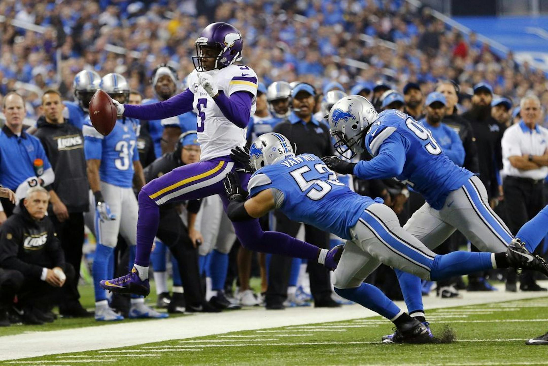 Minnesota Vikings quarterback Teddy Bridgewater (5) is pushed out of bounds by Detroit Lions outside linebacker Kyle Van Noy (53) and defensive end Ezekiel Ansah (94) during the first half of an NFL football game, Sunday, Oct. 25, 2015, in Detroit.