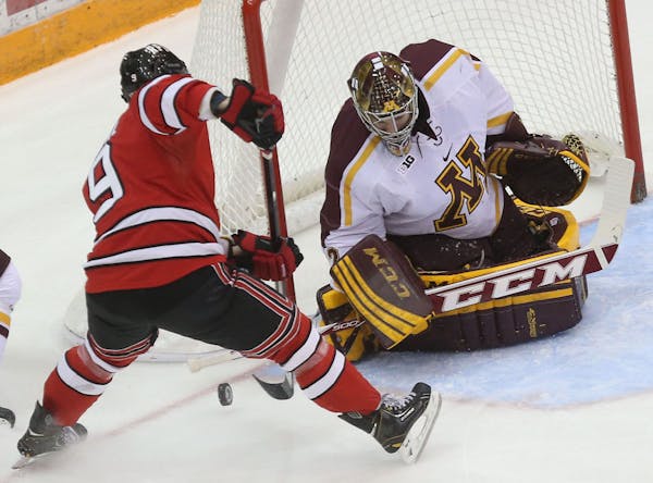 Gopher goalie Adam Wilcox made a save as RPI's Matt Neal made a shot on goal during the first period at Mariucci Arena in Minneapolis Saturday, Januar