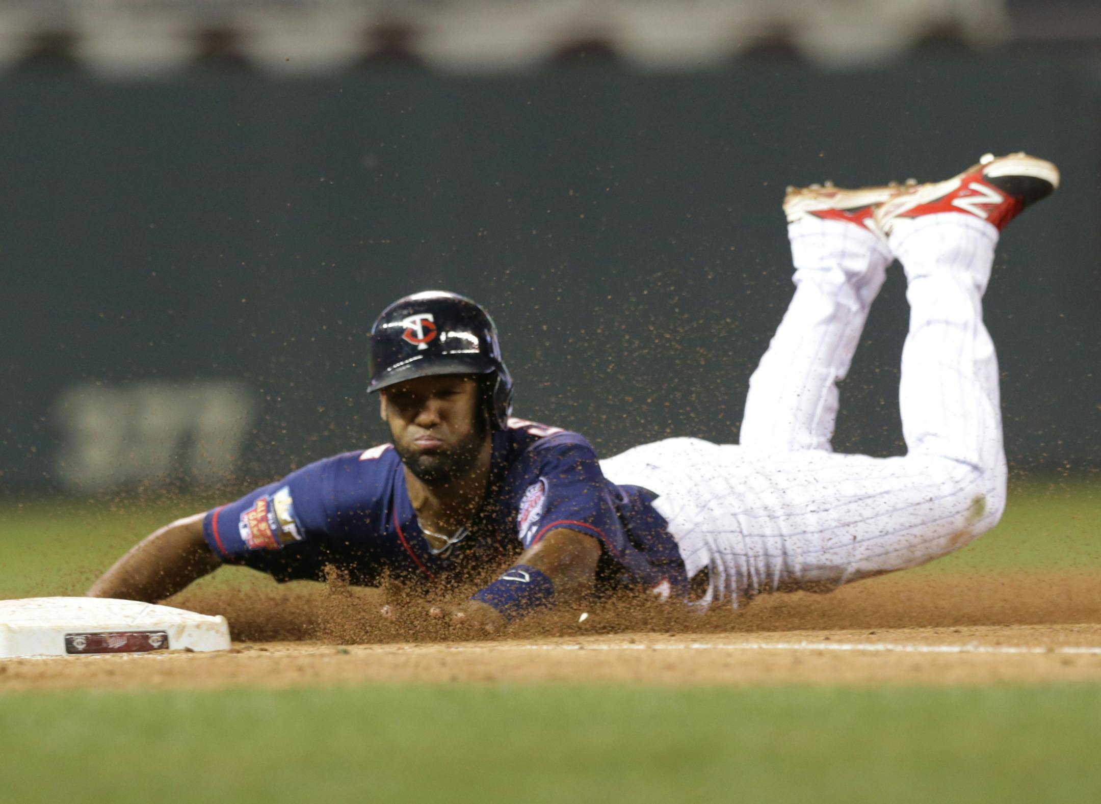 Minnesota Twins' Danny Santana advances to third on a single by Brian Dozier in the 10th inning of a baseball game against the Cleveland Indians, Friday, Sept. 19, 2014, in Minneapolis. Santana scored the winning run on a single by Trevor Plouffe as the Twins defeated the Indians 5-4. (AP Photo/Jim Mone)