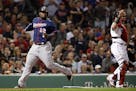 The Twins' Miguel Sano scores on a single by Willians Astudillo as Boston catcher Christian Vazquez stands at right during the seventh inning on Thurs