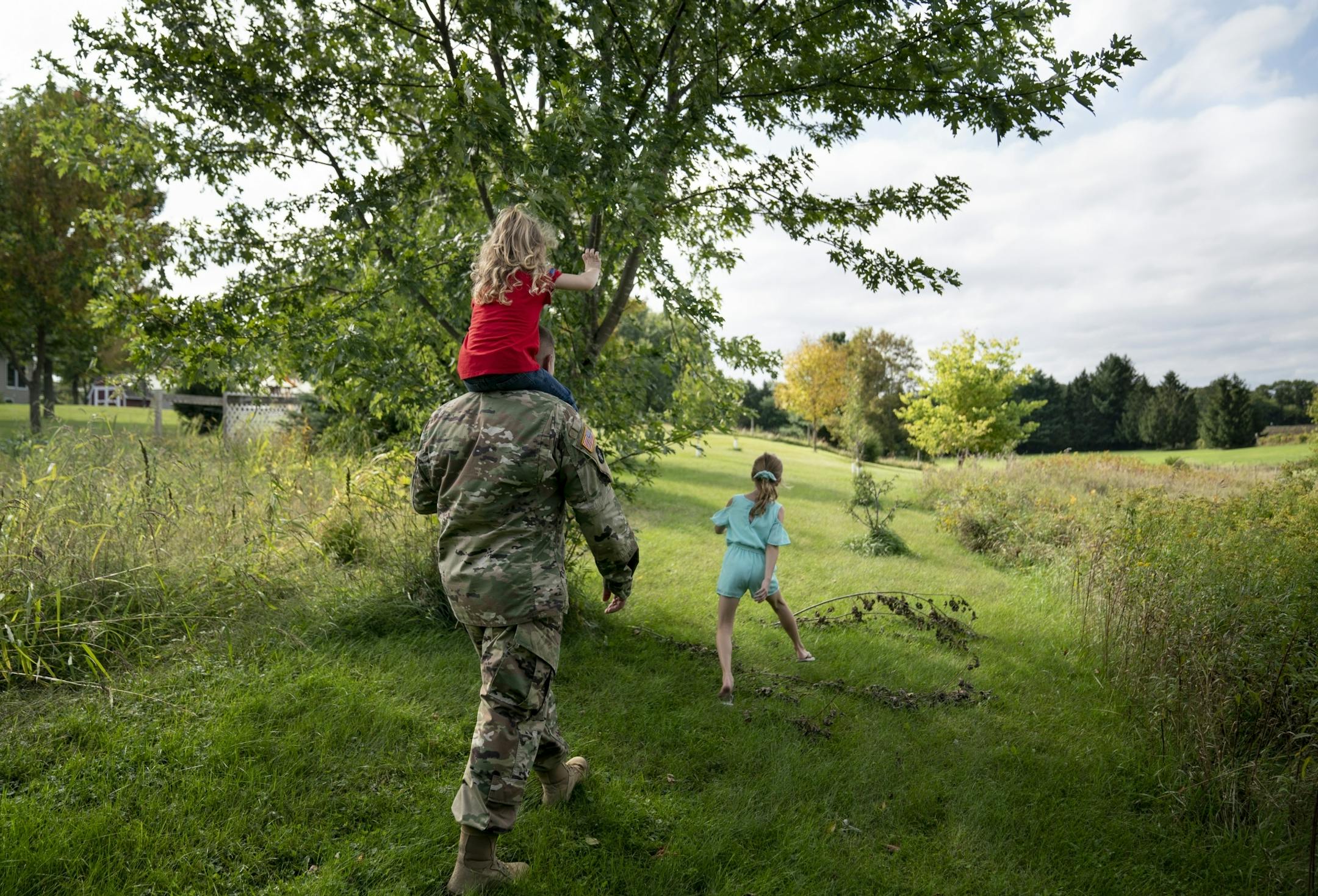 Brian Chafee took his daughters Ally, 3, and Madison, 8, on a walk to see their neighbor's horses in Scandia, Minn., on Wednesday, September 18, 2019. Brian will be taking care of his girls alone as his wife deploys to Iraq for 12 months.
