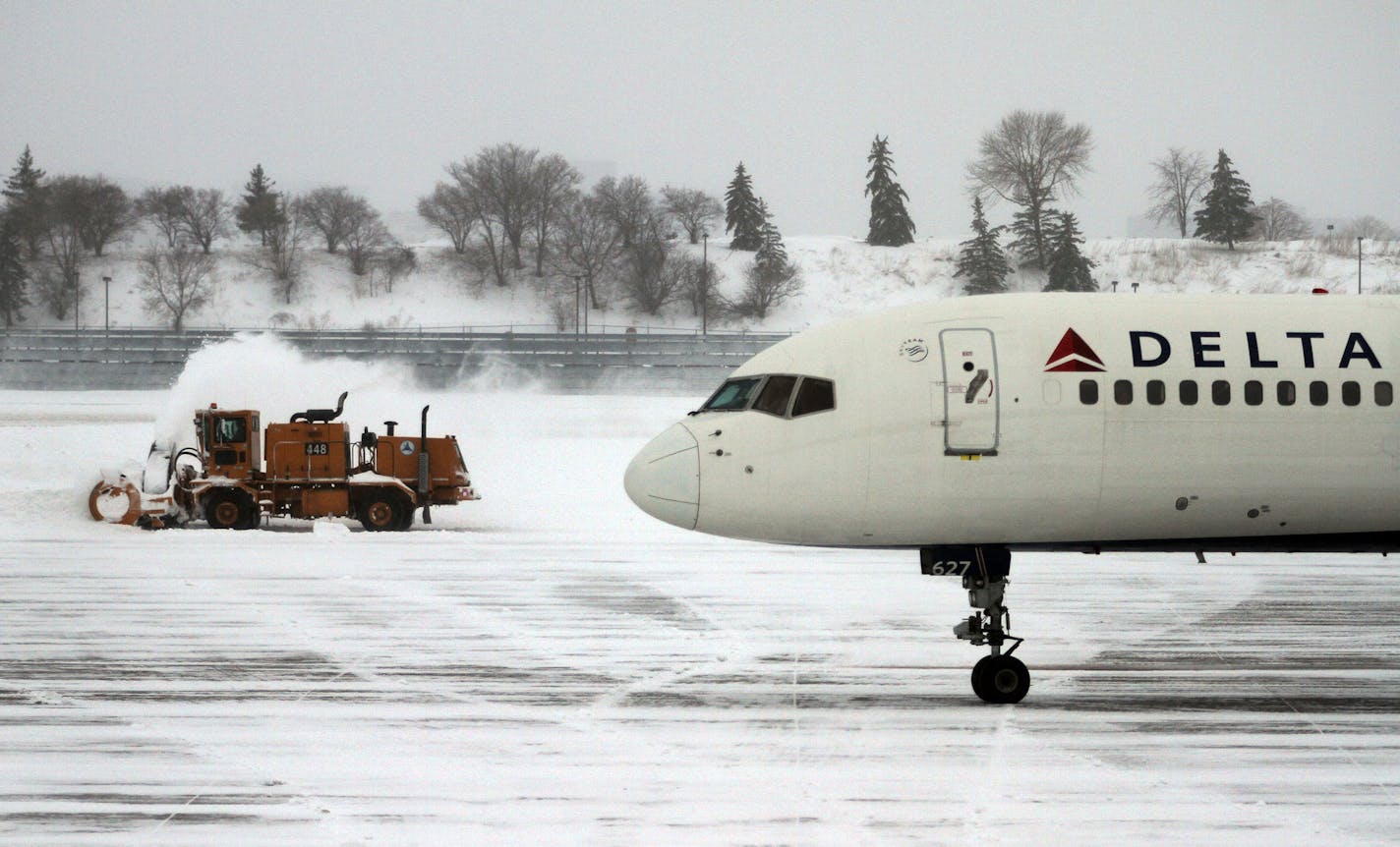 Airport crews worked to clear off the tarmac after a heavy snowfall early Monday morning, Feb. 21, 2011, at Minneapolis-St. Paul International Airport in Minneapolis. Operations were returning to normal at the airport after the storm prompted Delta Airlines to cancel hundreds of flights Sunday, although delays were reported. (AP Photo/Star Tribune, McKenna Ewen) ** ST. PAUL OUT MINNEAPOLIS-AREA TV OUT MAGS OUT ** ORG XMIT: MIN2016020112141625