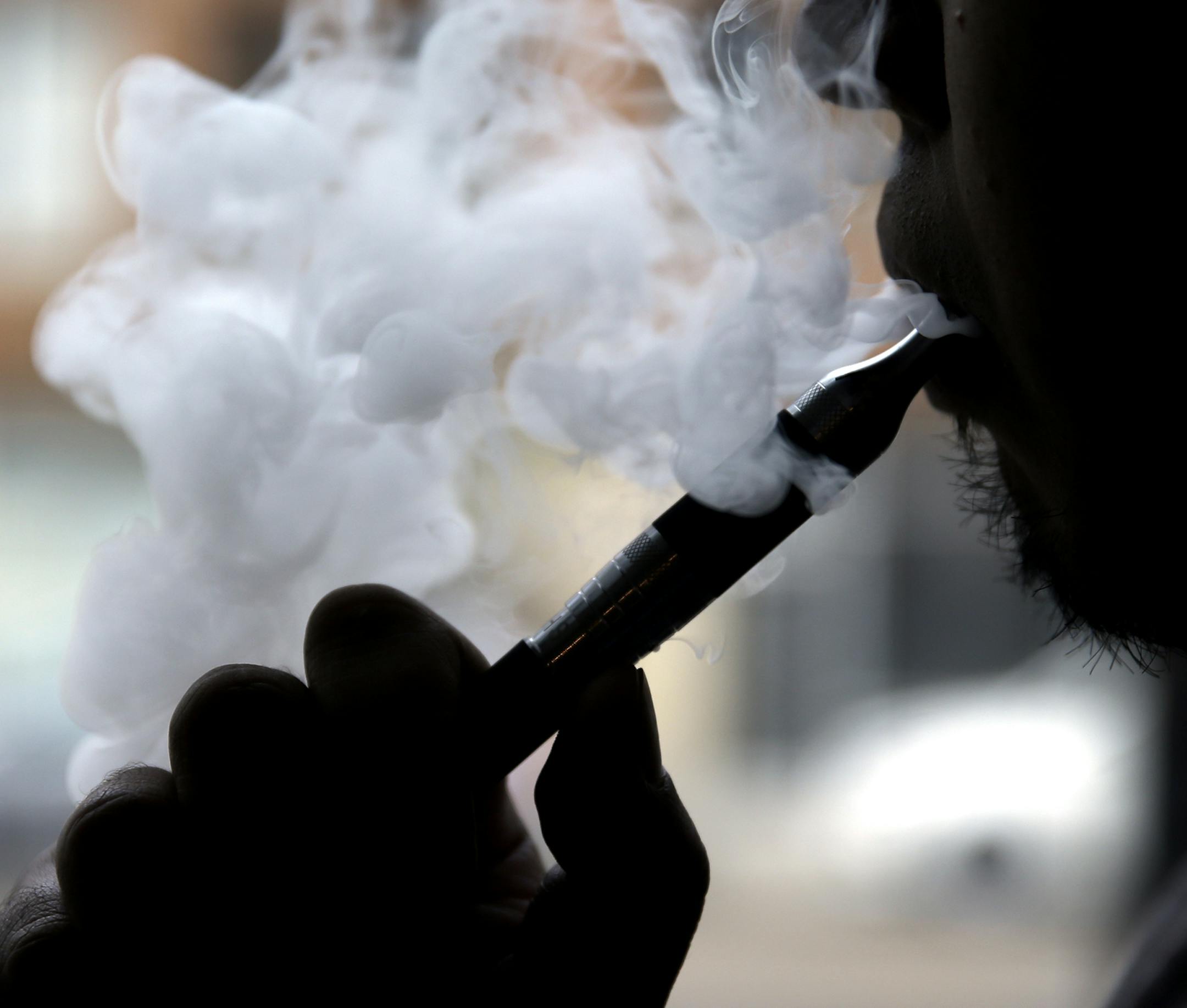 Daryl Cura demonstrates an e-cigarette at Vape store in Chicago, Wednesday, April 23, 2014. The federal government wants to ban sales of electronic cigarettes to minors and require approval for new products and health warning labels under regulations being proposed by the Food and Drug Administration. (AP Photo/Nam Y. Huh) ORG XMIT: MIN2014042911470825
