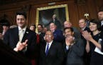 House Speaker Paul Ryan of Wis., left, leads applause for House Ways and Means Chair Rep. Kevin Brady, R-Texas, along with Rep. Carlos Curbelo, R-Fla.