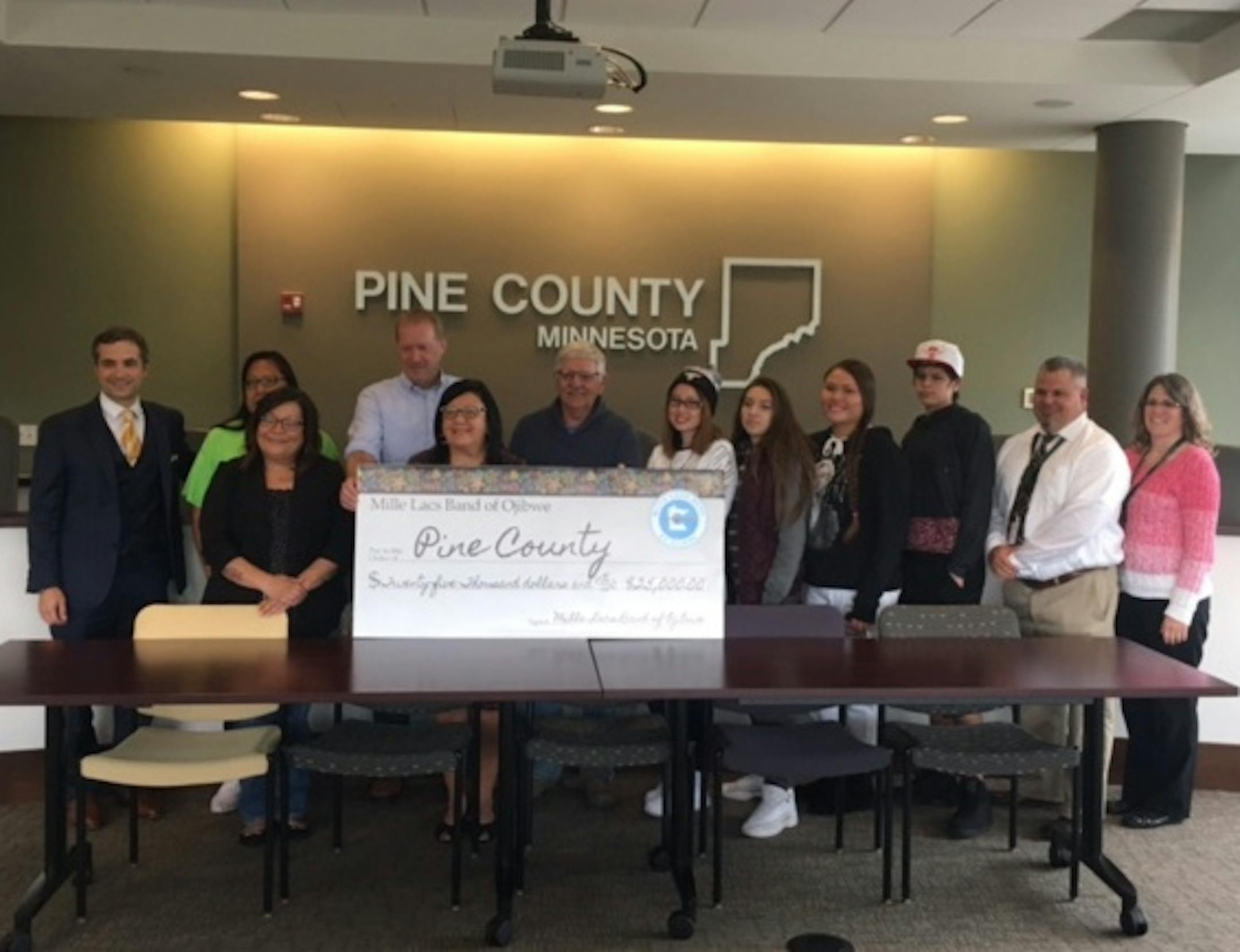 Leaders from Pine County and the Mille Lacs Band of Ojibwe celebrate the $25,000 donation from the Band to the county to help fund the start of a cultural community coach to work with kids in probation.