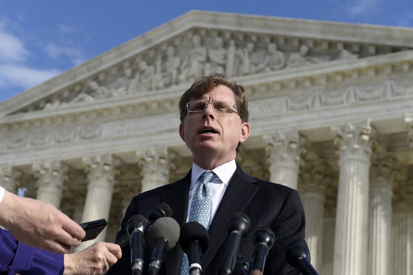 FILE - In this Dec. 1, 2014 file photo, John P. Elwood, attorney for Anthony D. Elonis, who claimed he was just kidding when he posted a series of graphically violent rap lyrics on Facebook about killing his estranged wife, shooting up a kindergarten class and attacking an FBI agent, speaks to reporters outside the Supreme Court in Washington. The Supreme Court on Monday threw out the conviction of a Pennsylvania man convicted of making threats on Facebook, but dodged the free speech issues that