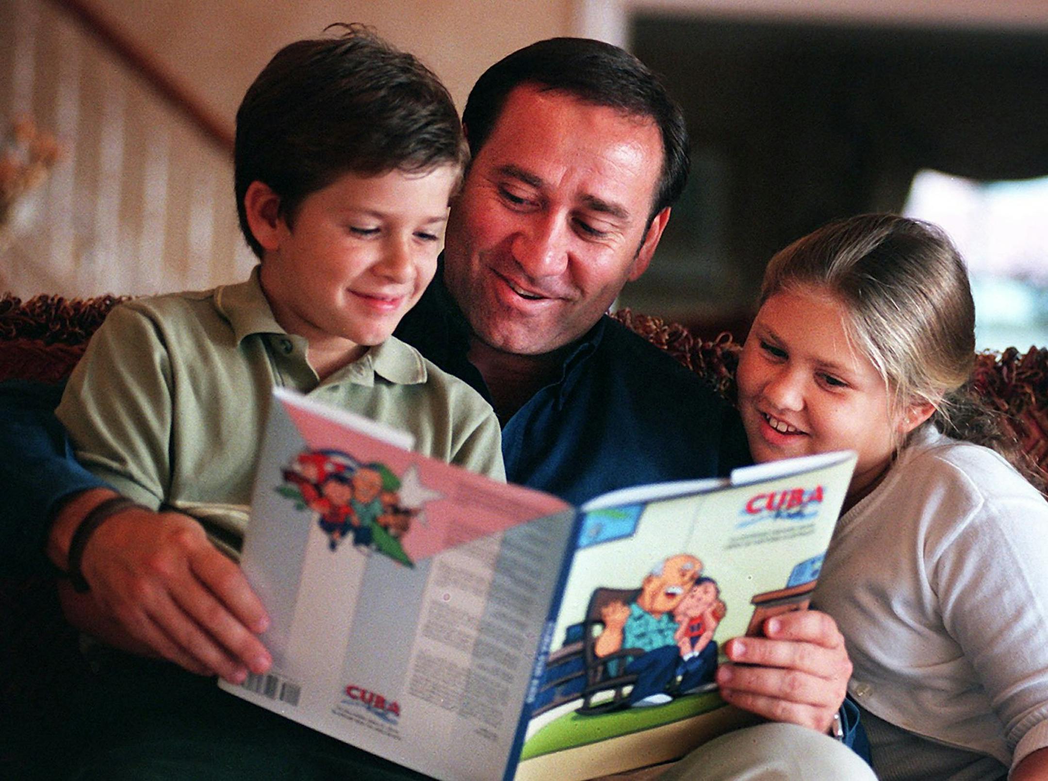 KRT SOUTH STORY SLUGGED: FL-CUBAKIDS KRT PHOTOGRAPH BY PETER ANDREW BOSCH/MIAMI HERALD (FORT LAUDERDALE OUT) (November 17) Dr. Ismael Roque-Velasco, author of "Cuba for Kids," reads to his children, Javier, 7, and Gabriela, 10. (MI) PL KD 2000 (Horiz) (lde) -- NO MAGS, NO SALES -- (Diversity) ORG XMIT: KRTS