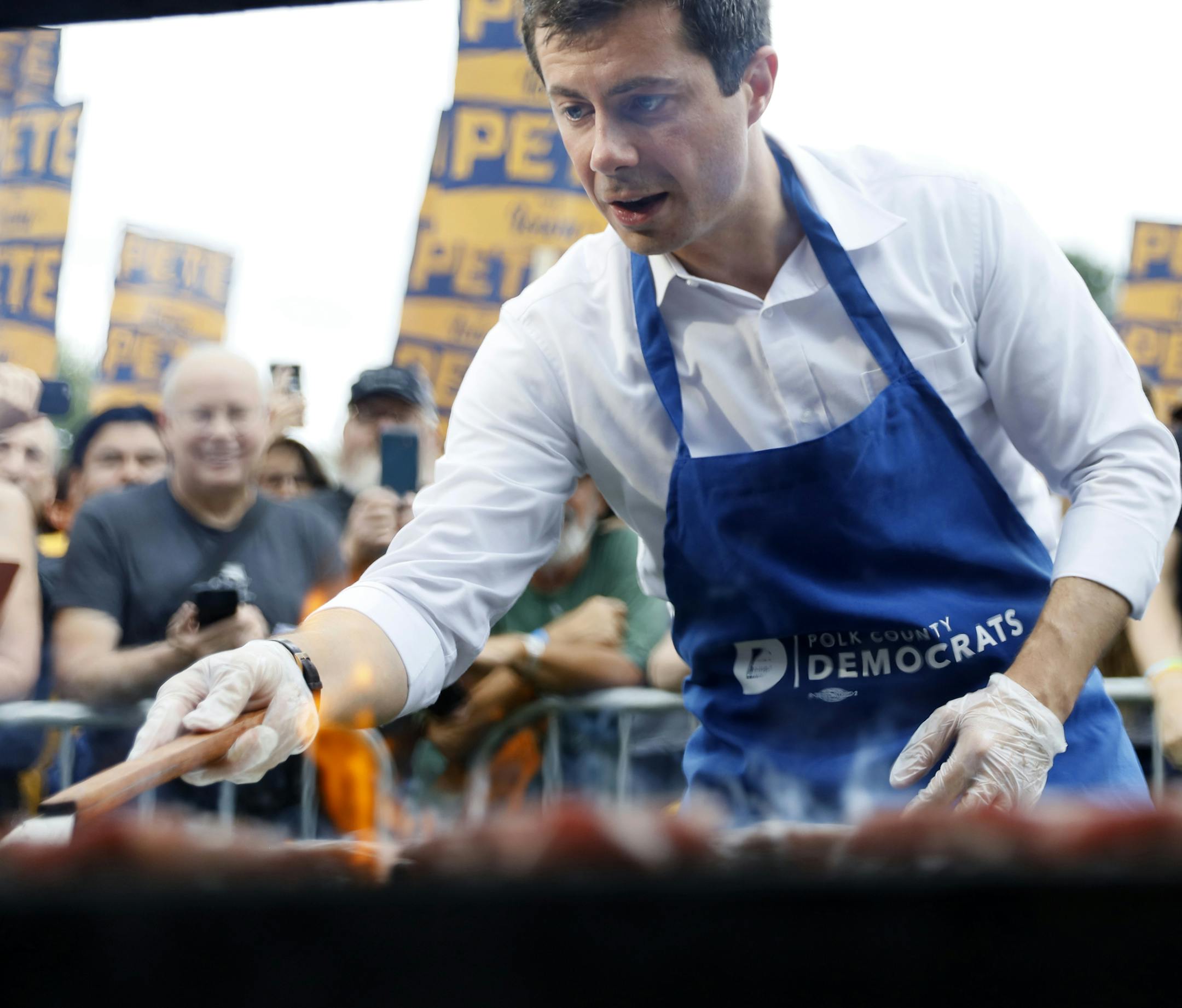 Democratic presidential candidate Pete Buttigieg works the grill during the Polk County Democrats Steak Fry, Saturday, Sept. 21, 2019, in Des Moines, Iowa. (AP Photo/Charlie Neibergall)